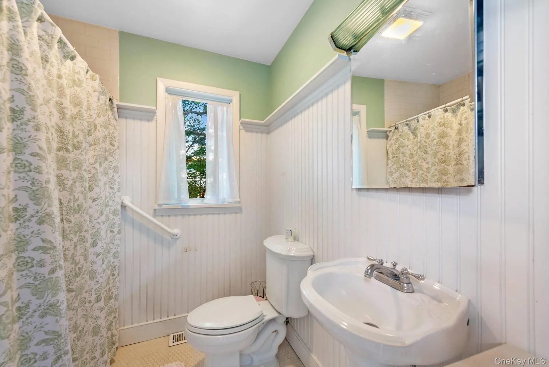 Full bath featuring toilet and a shower with shower curtain Full bath featuring toilet and a shower with shower curtain