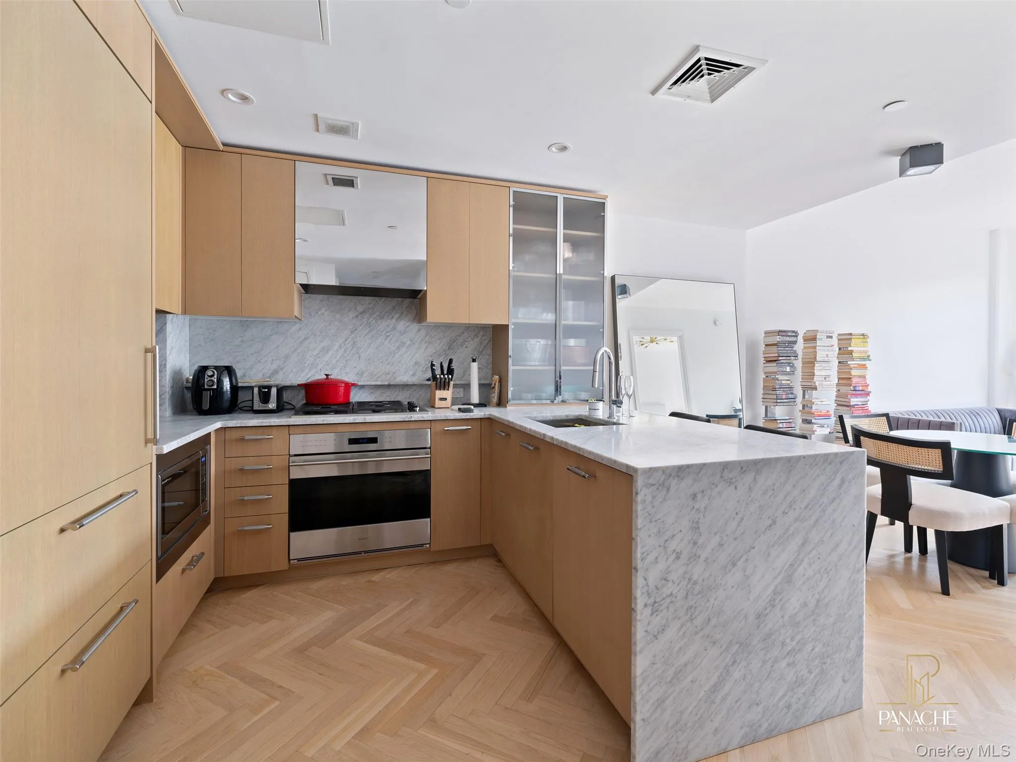Kitchen with a peninsula, light brown cabinets, modern cabinets, and recessed lighting Kitchen with a peninsula, light brown cabinets, modern cabinets, and recessed lighting