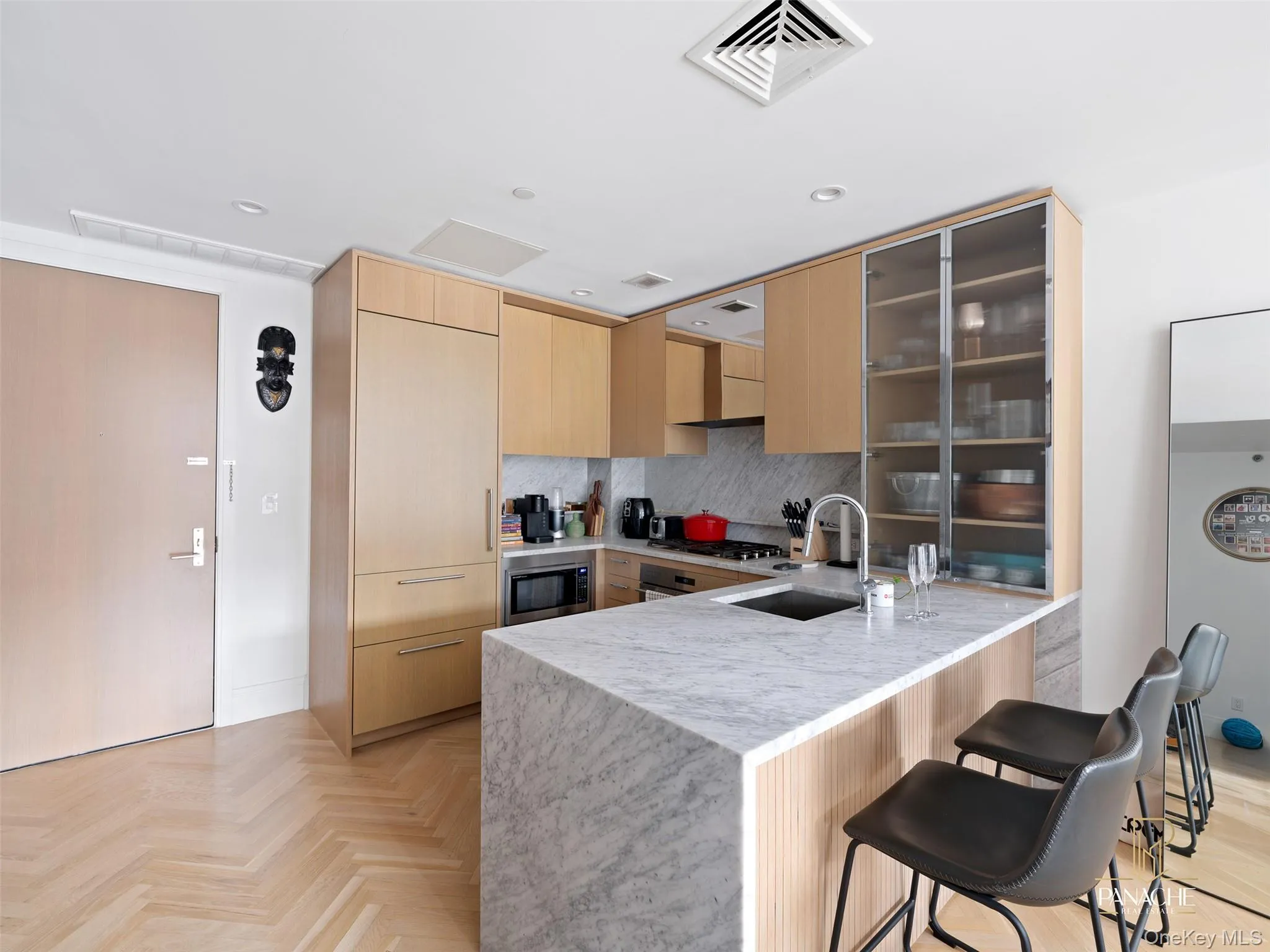 Kitchen featuring light brown cabinets, a kitchen breakfast bar, decorative backsplash, modern cabinets, and a peninsula Kitchen featuring light brown cabinets, a kitchen breakfast bar, decorative backsplash, modern cabinets, and a peninsula