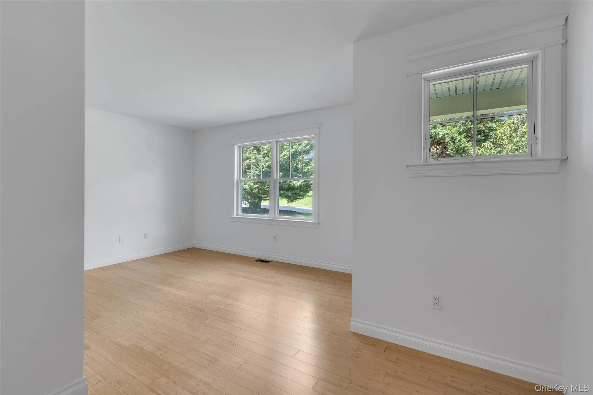 Spare room featuring baseboards and light wood-style floors Spare room featuring baseboards and light wood-style floors