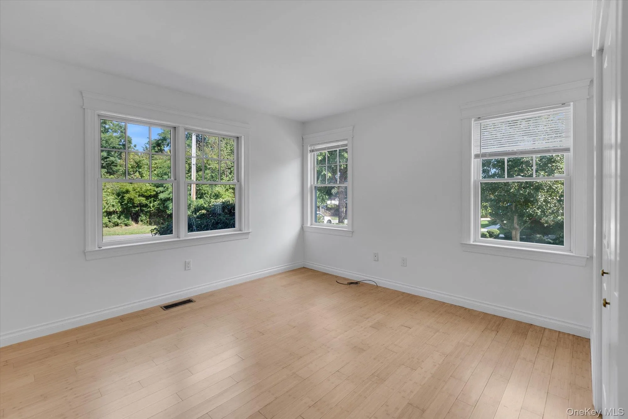 Unfurnished room with baseboards and light wood-style flooring Unfurnished room with baseboards and light wood-style flooring