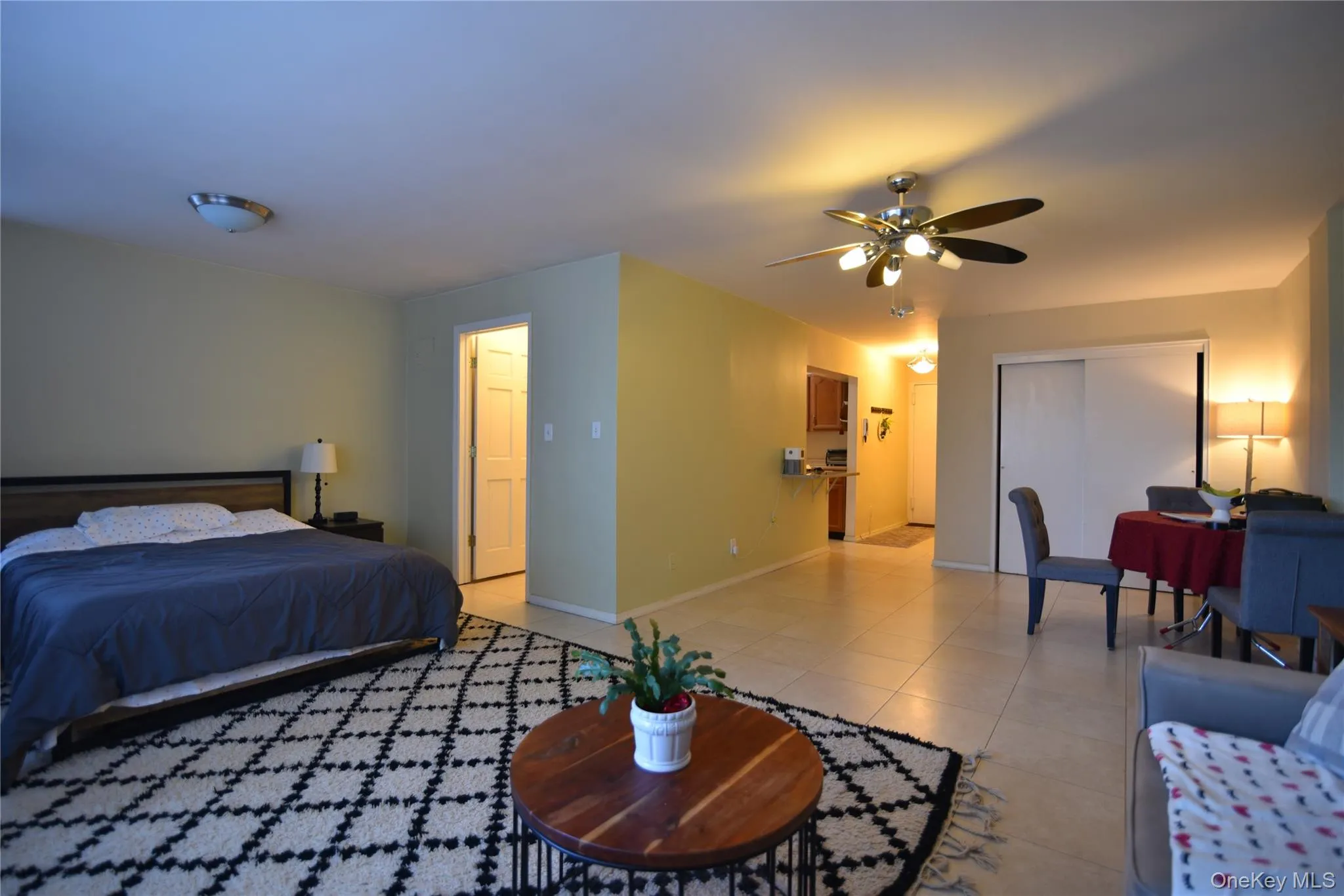 Bedroom featuring a closet, light tile patterned floors, and ceiling fan Bedroom featuring a closet, light tile patterned floors, and ceiling fan