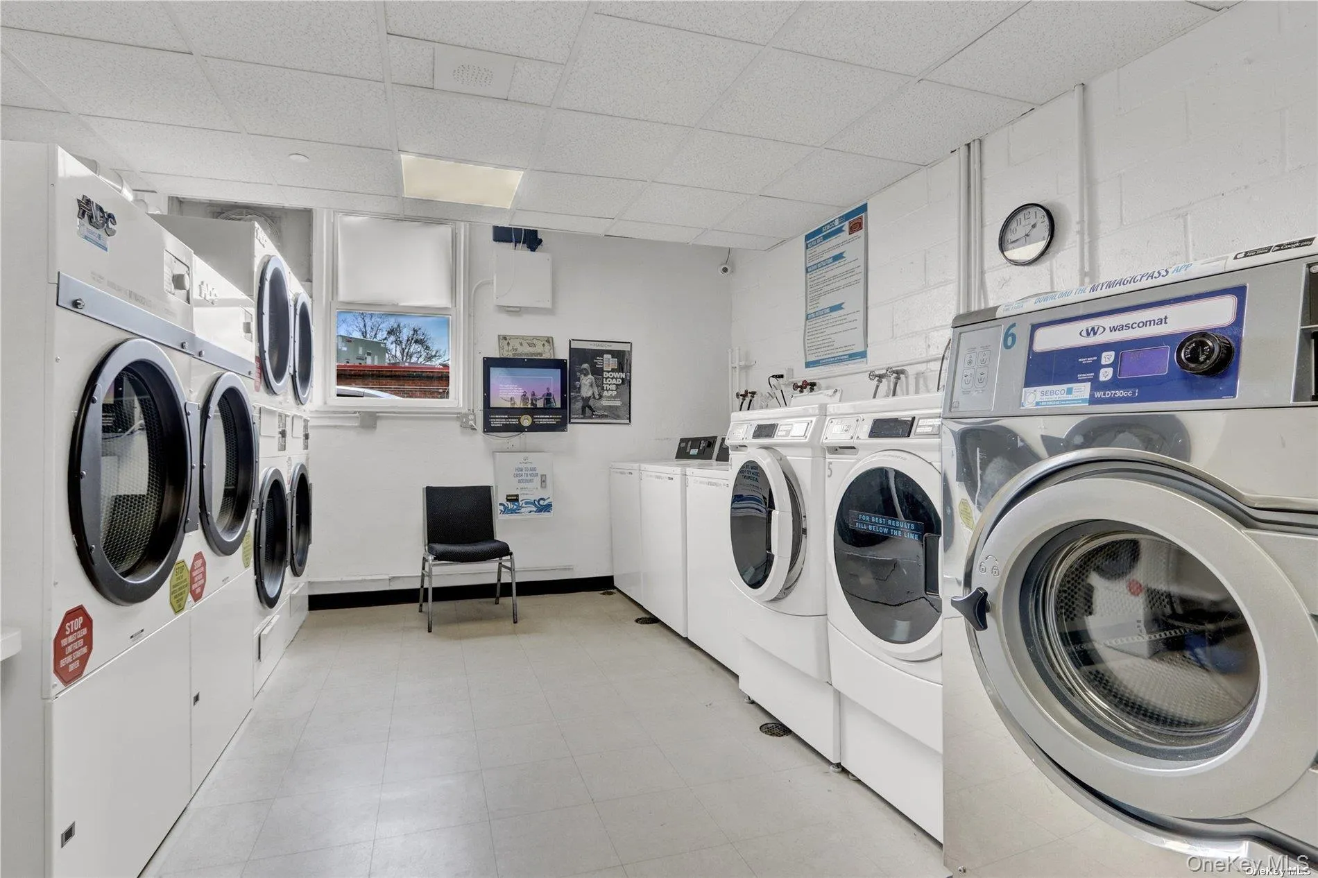Community laundry room featuring separate washer and dryer and light flooring Community laundry room featuring separate washer and dryer and light flooring