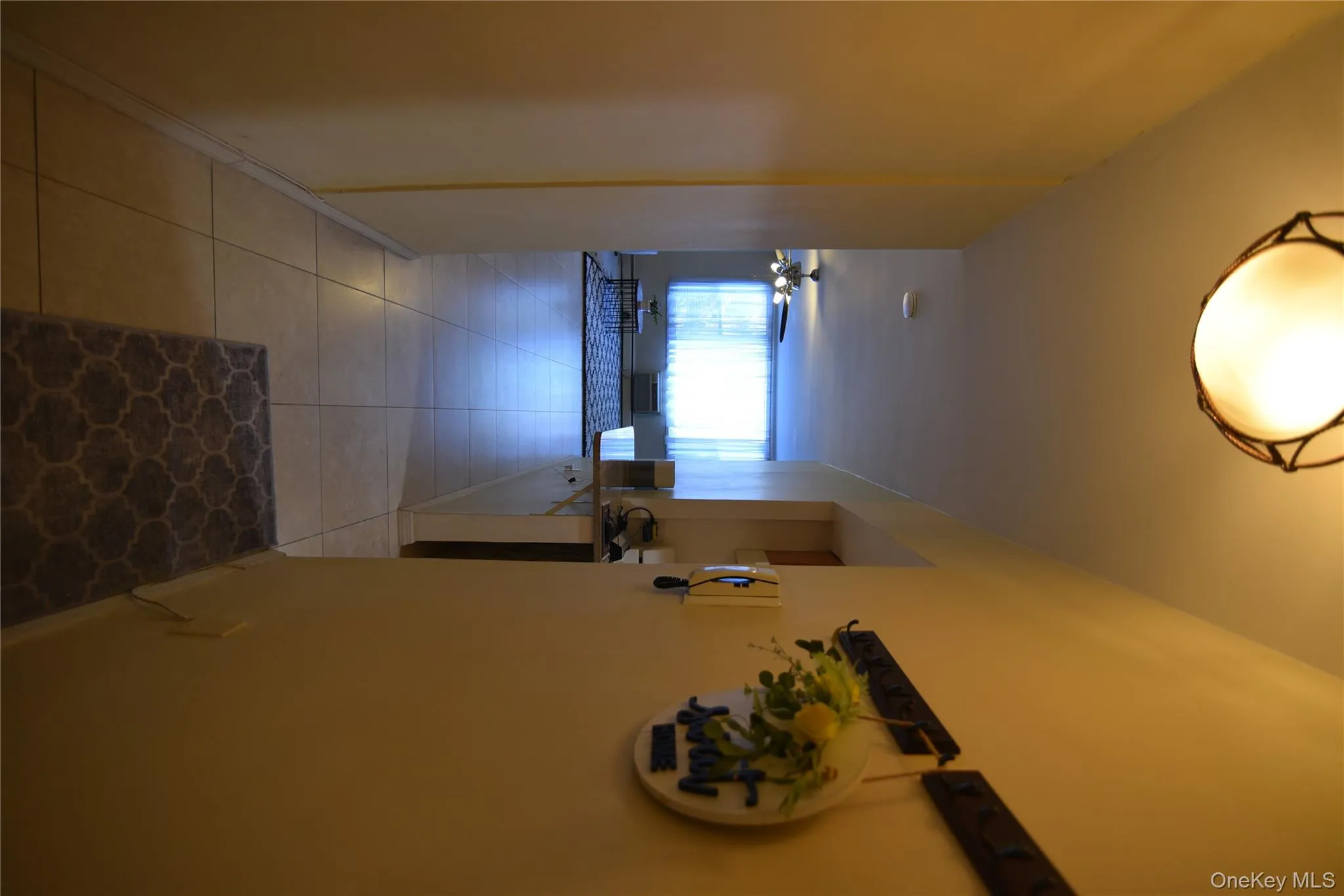 Hall featuring light tile patterned flooring and baseboards Hall featuring light tile patterned flooring and baseboards