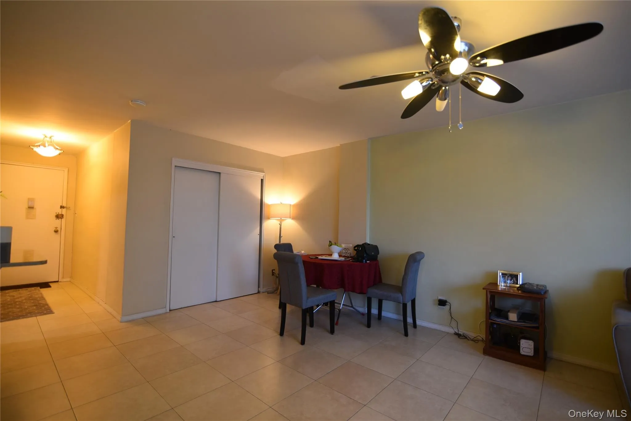 Living area featuring ceiling fan and light tile patterned floors Living area featuring ceiling fan and light tile patterned floors