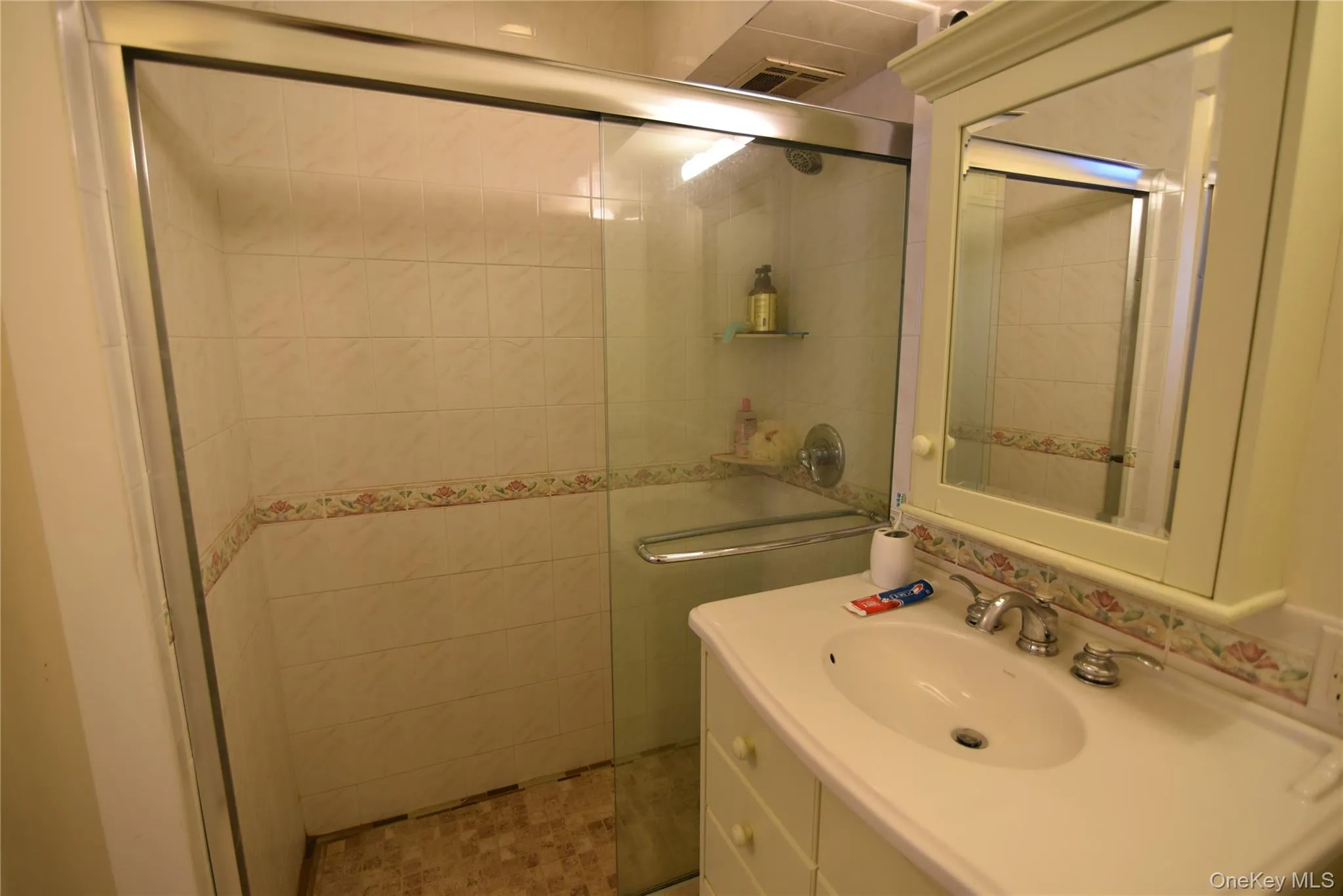 Bathroom with vanity, a walk in shower, and tile walls Bathroom with vanity, a walk in shower, and tile walls