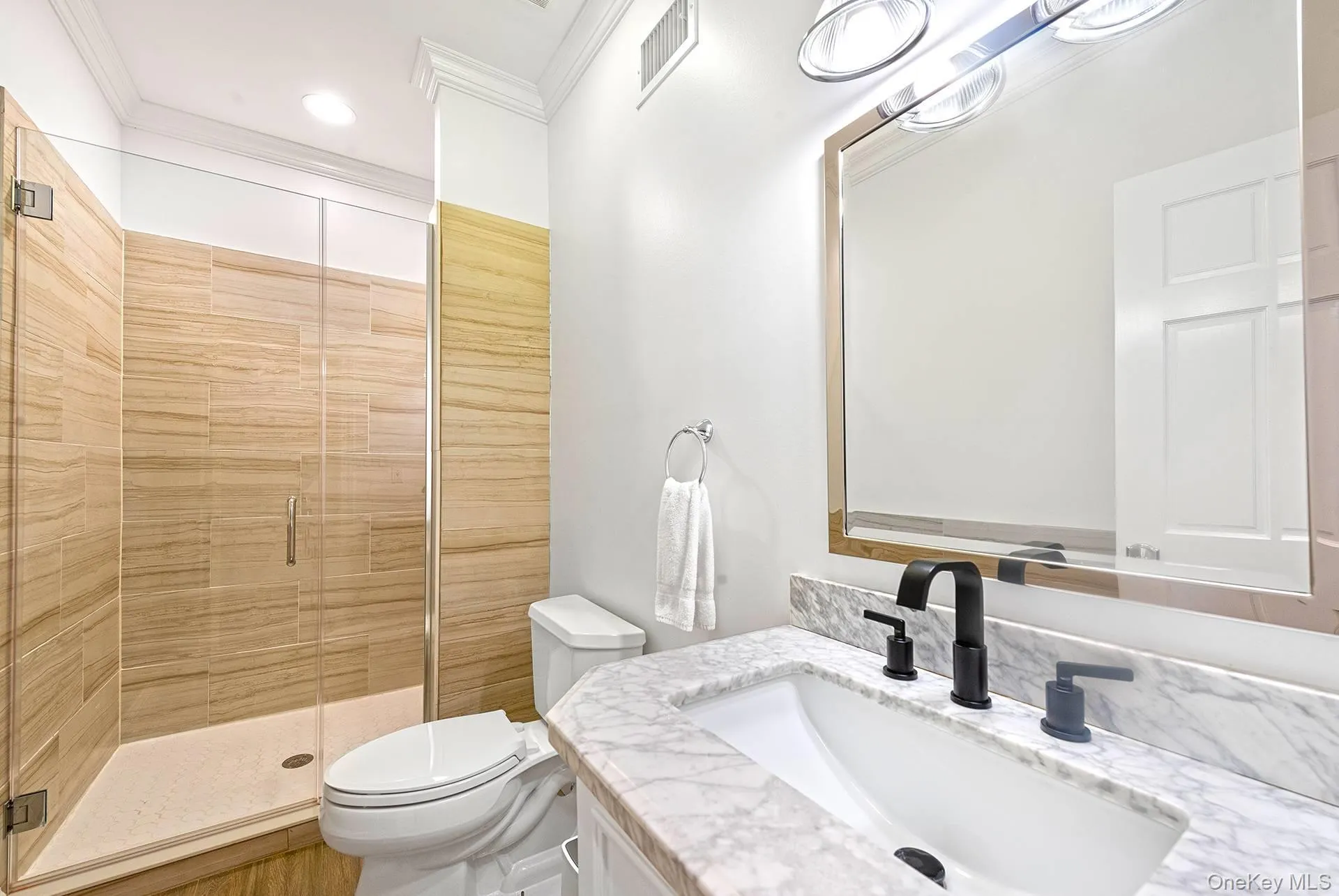 Bathroom with vanity, a shower stall, and crown molding Bathroom with vanity, a shower stall, and crown molding
