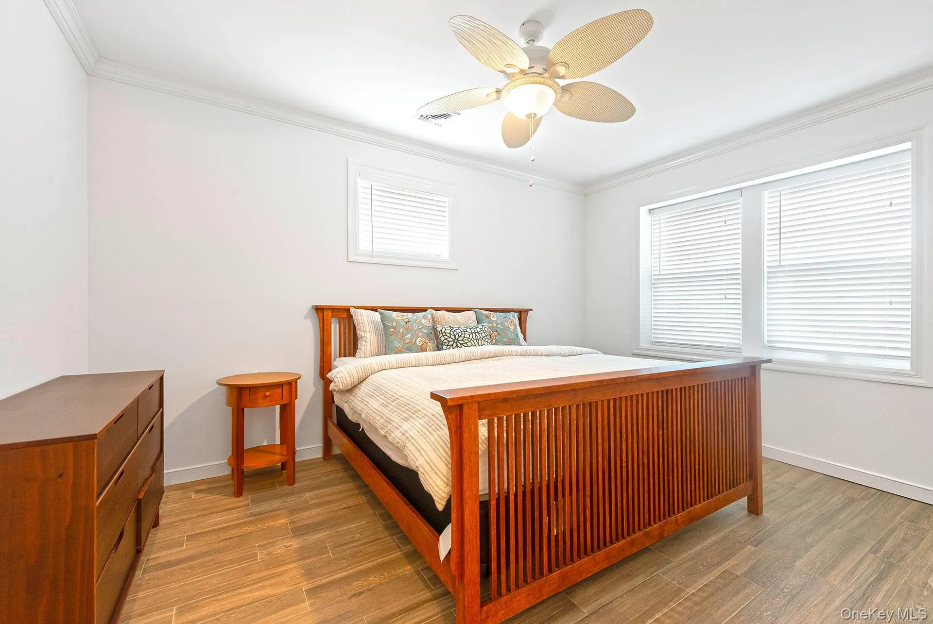 Bedroom with ornamental molding, wood finished floors, and ceiling fan Bedroom with ornamental molding, wood finished floors, and ceiling fan