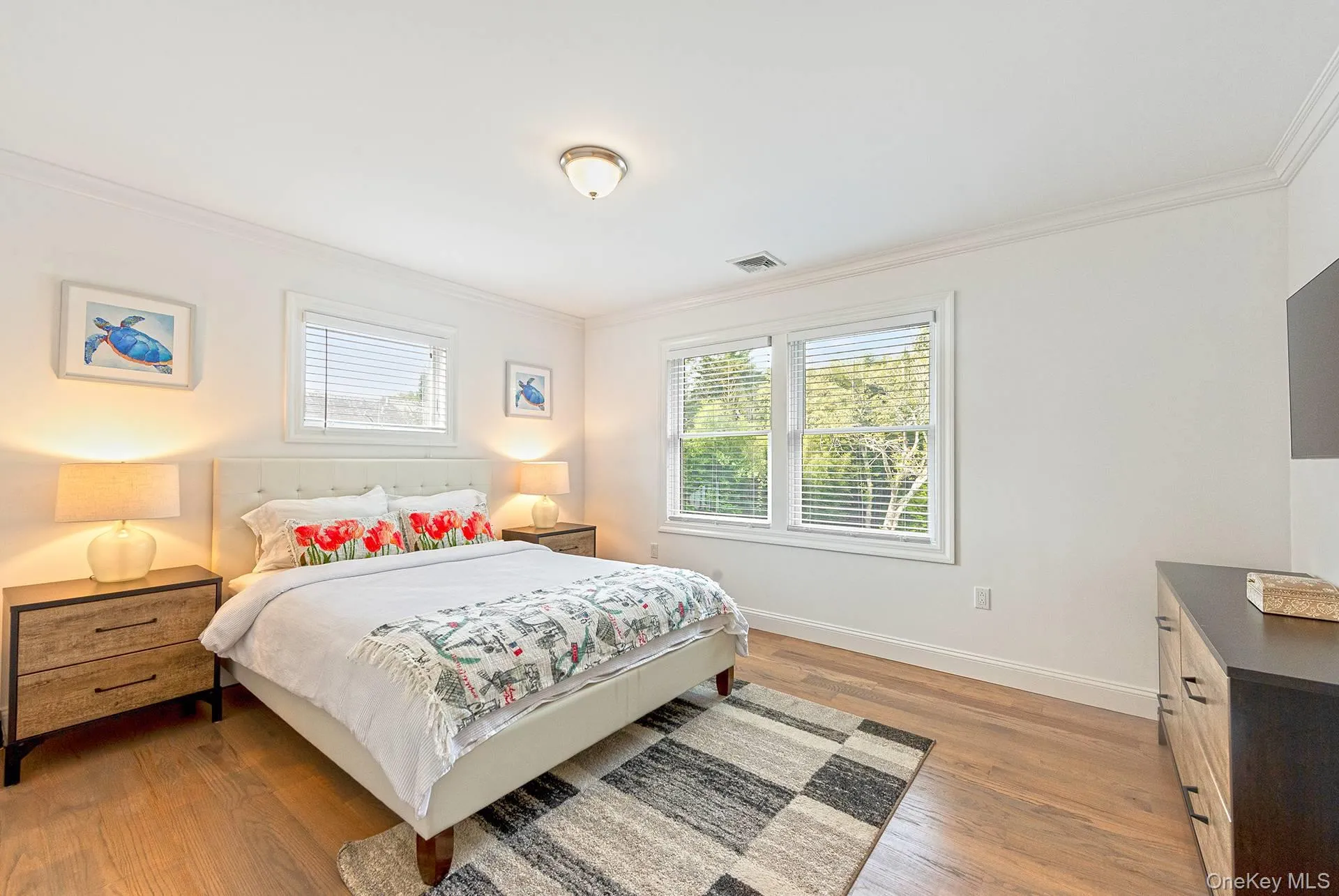 Bedroom featuring ornamental molding and light wood-type flooring Bedroom featuring ornamental molding and light wood-type flooring