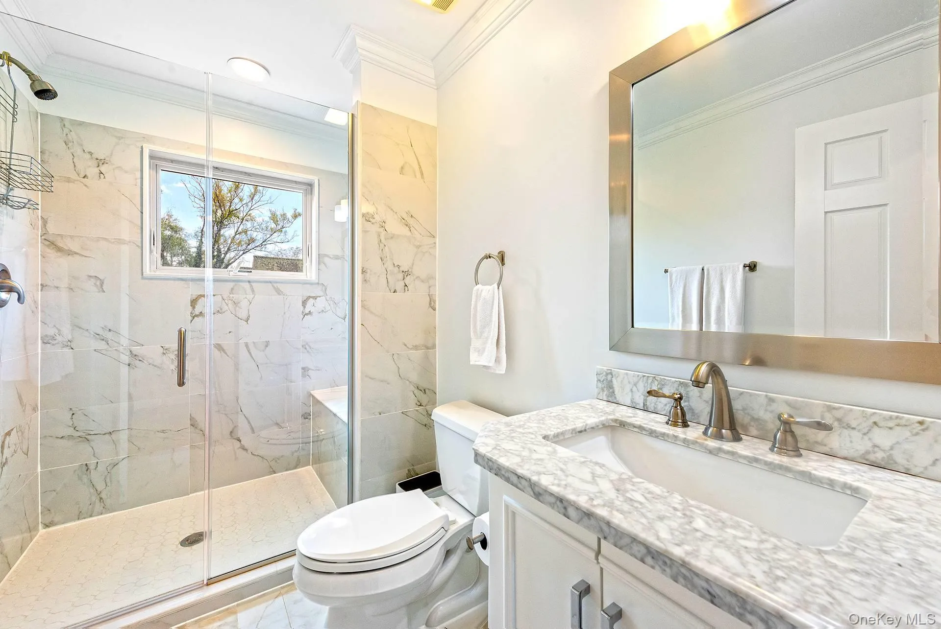 Bathroom featuring vanity, a marble finish shower, and crown molding Bathroom featuring vanity, a marble finish shower, and crown molding