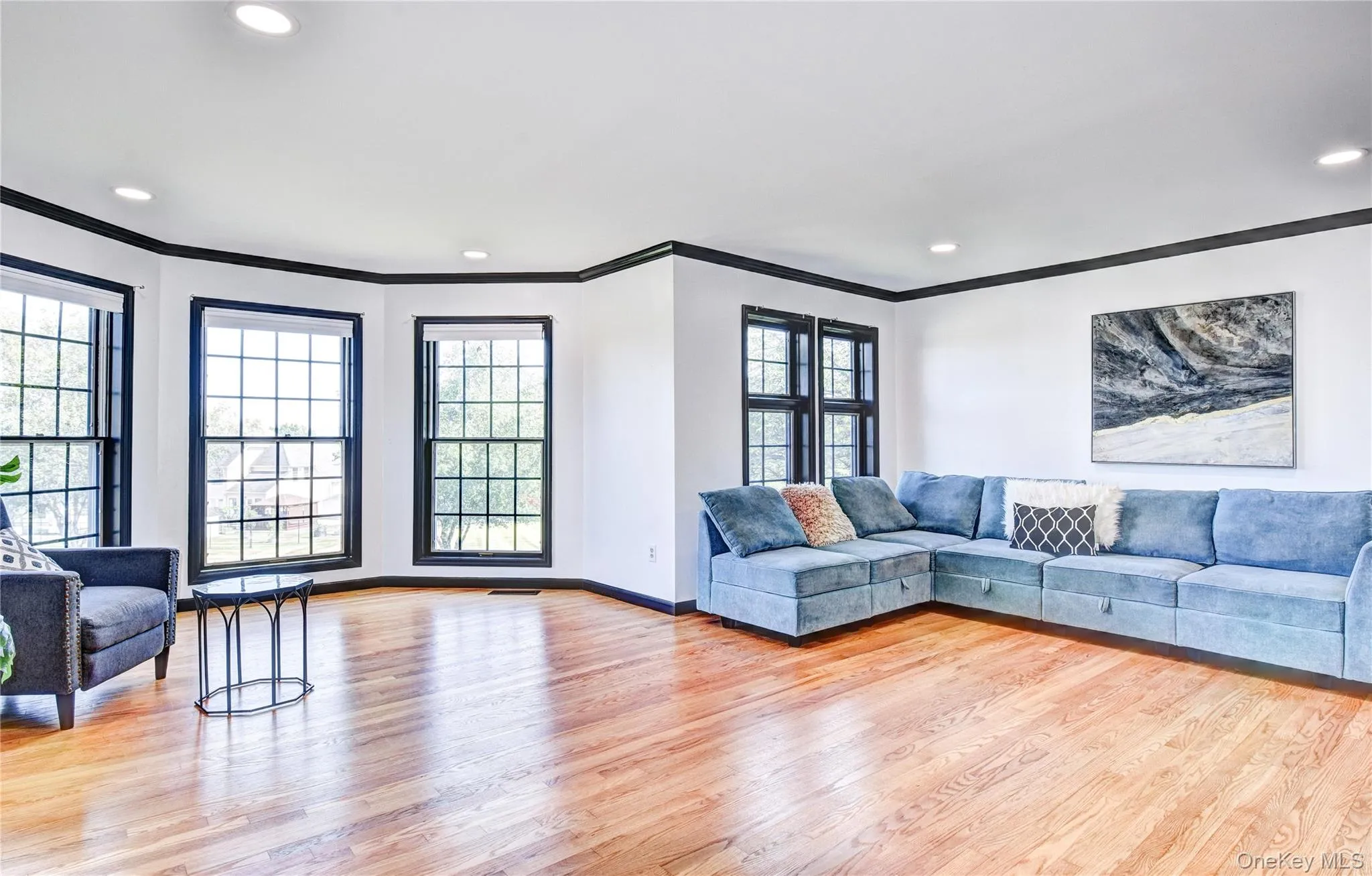 Living room featuring crown molding and hardwood floors Living room featuring crown molding and hardwood floors