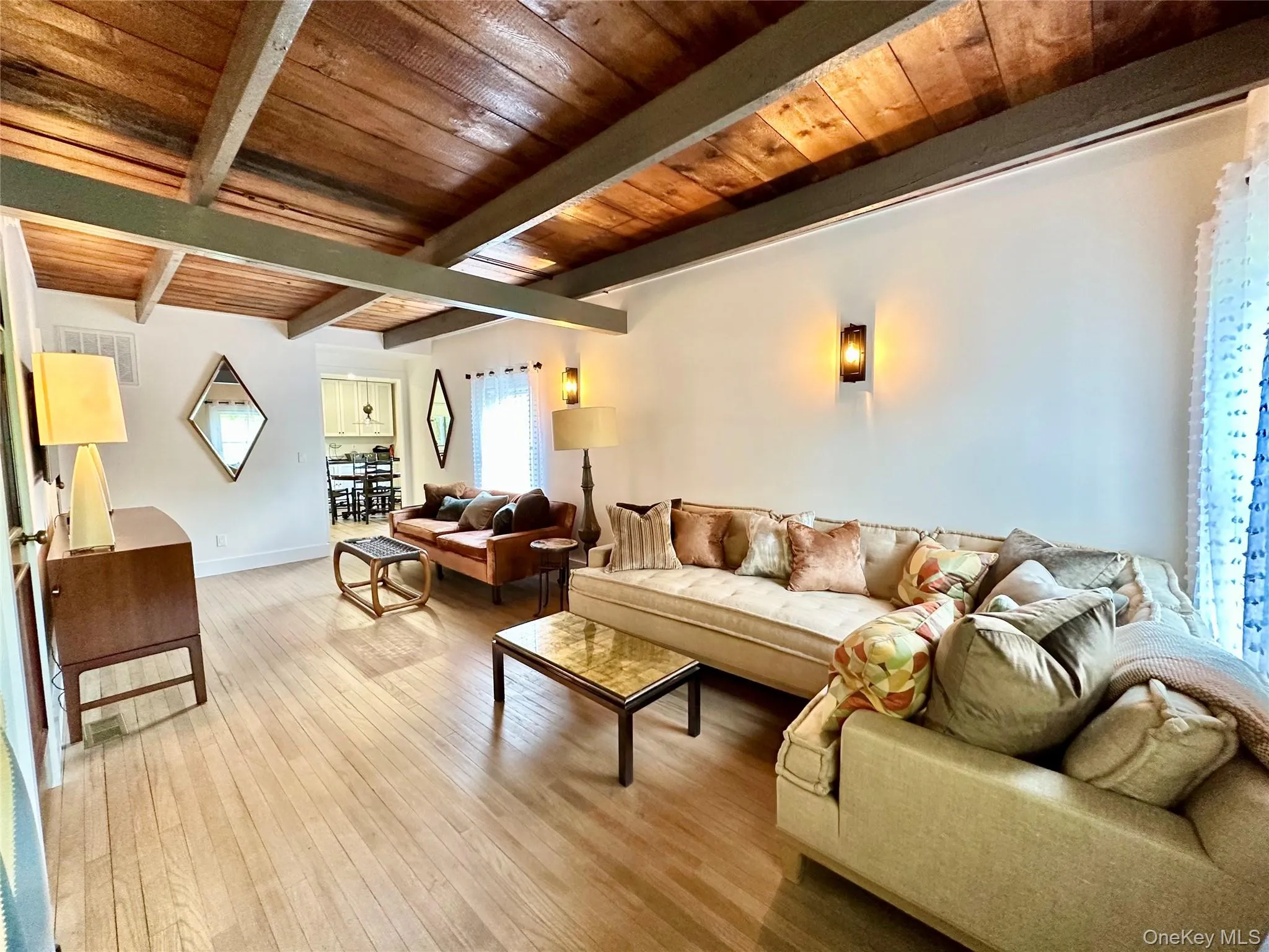 Living area with light wood-type flooring and a wooden ceiling with exposed beams Living area with light wood-type flooring and a wooden ceiling with exposed beams