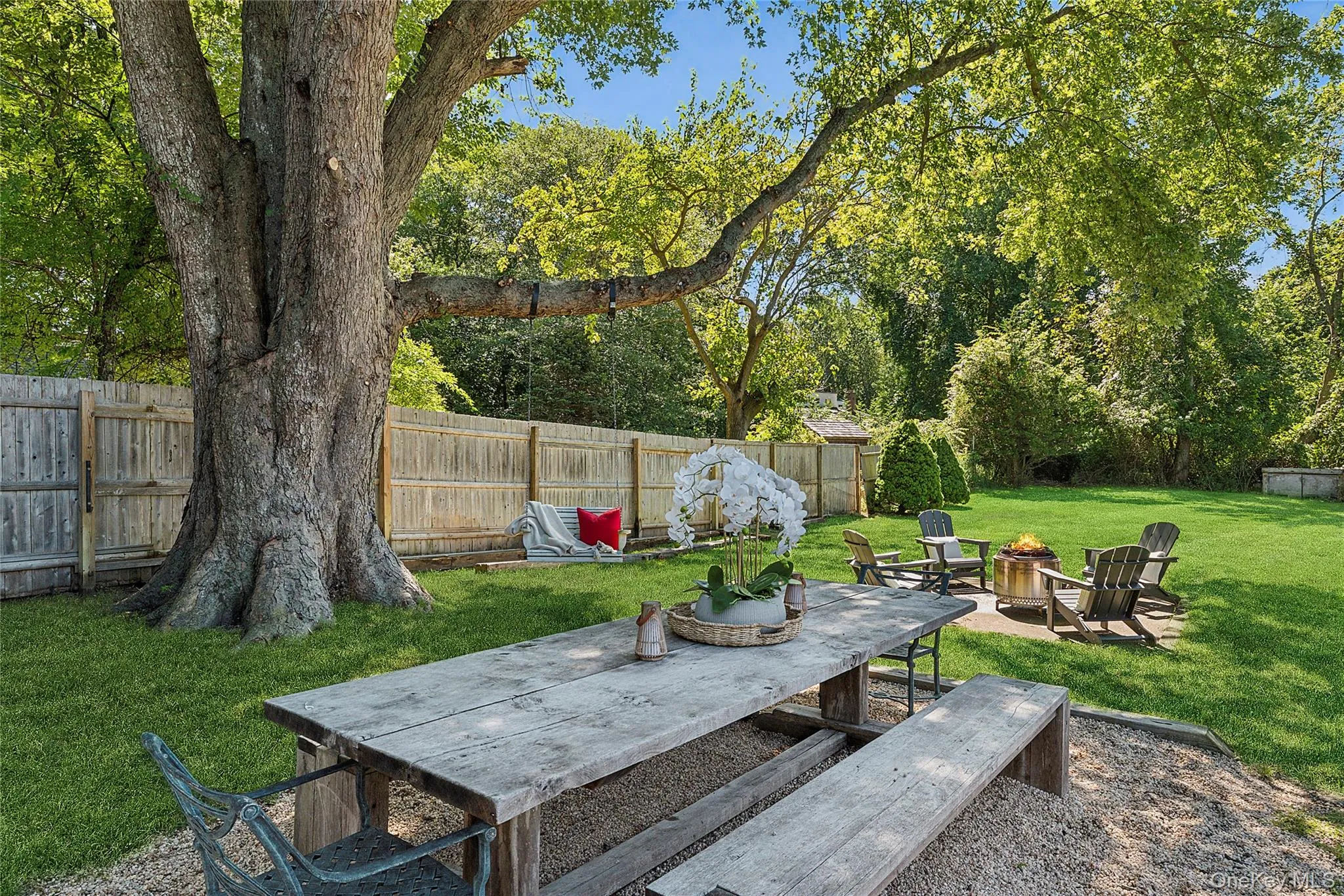 Fenced backyard with an outdoor fire pit and a patio area Fenced backyard with an outdoor fire pit and a patio area