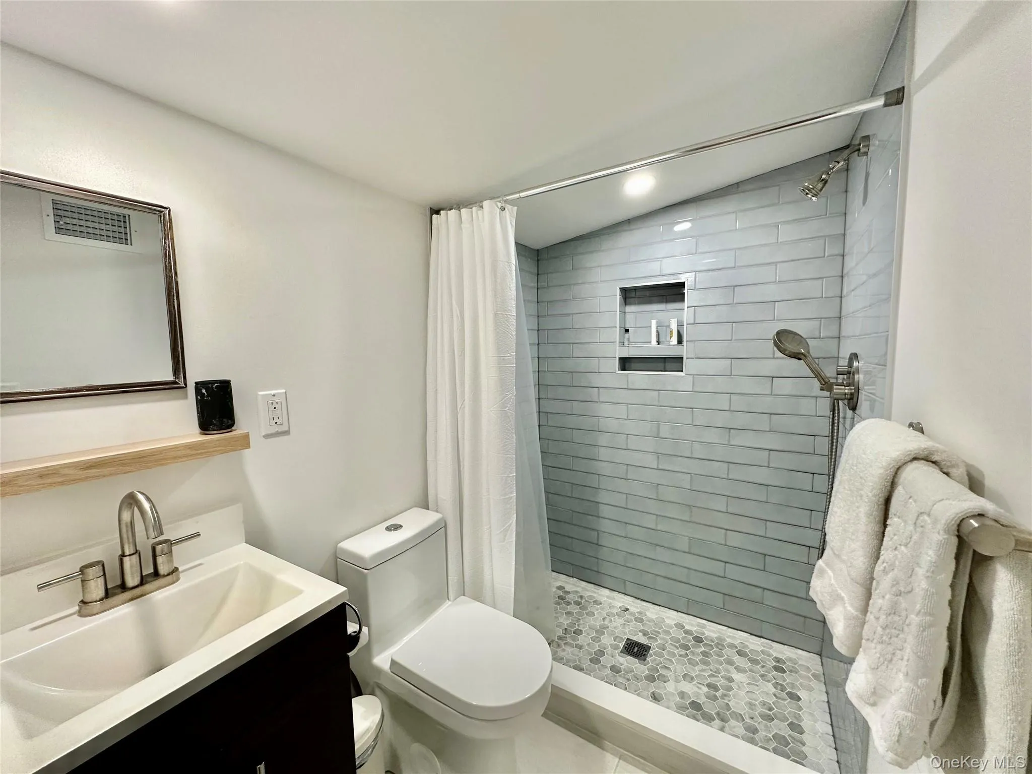 Bathroom featuring vanity, a stall shower, recessed lighting, and lofted ceiling Bathroom featuring vanity, a stall shower, recessed lighting, and lofted ceiling