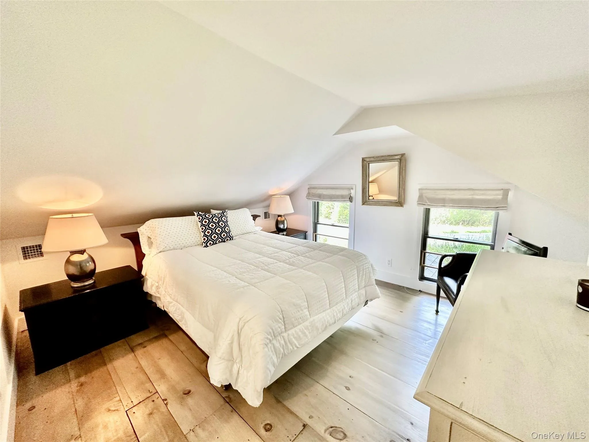 Bedroom featuring light wood-style floors and vaulted ceiling Bedroom featuring light wood-style floors and vaulted ceiling