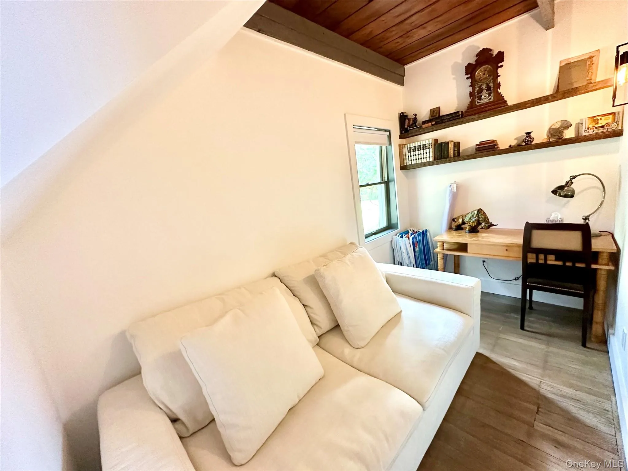 Living room with a wooden ceiling with exposed beams, a desk, and wood finished floors Living room with a wooden ceiling with exposed beams, a desk, and wood finished floors