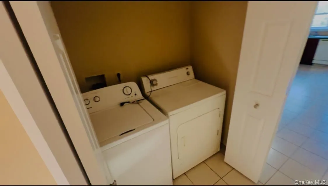Laundry area featuring light tile patterned floors and washer and dryer Laundry area featuring light tile patterned floors and washer and dryer