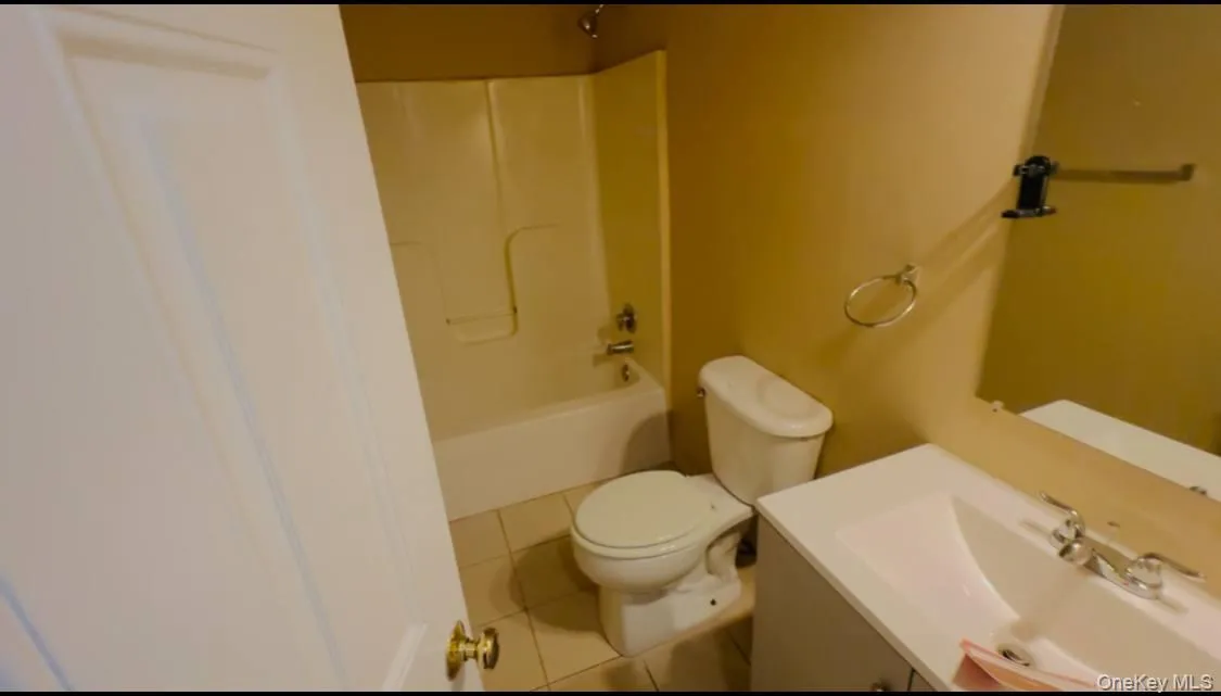 Bathroom featuring tile patterned floors, vanity, and bathtub / shower combination Bathroom featuring tile patterned floors, vanity, and bathtub / shower combination