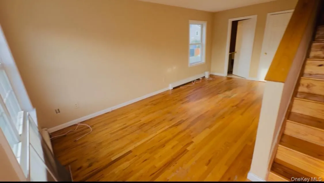 Unfurnished bedroom featuring two closets and wood finished floors Unfurnished bedroom featuring two closets and wood finished floors