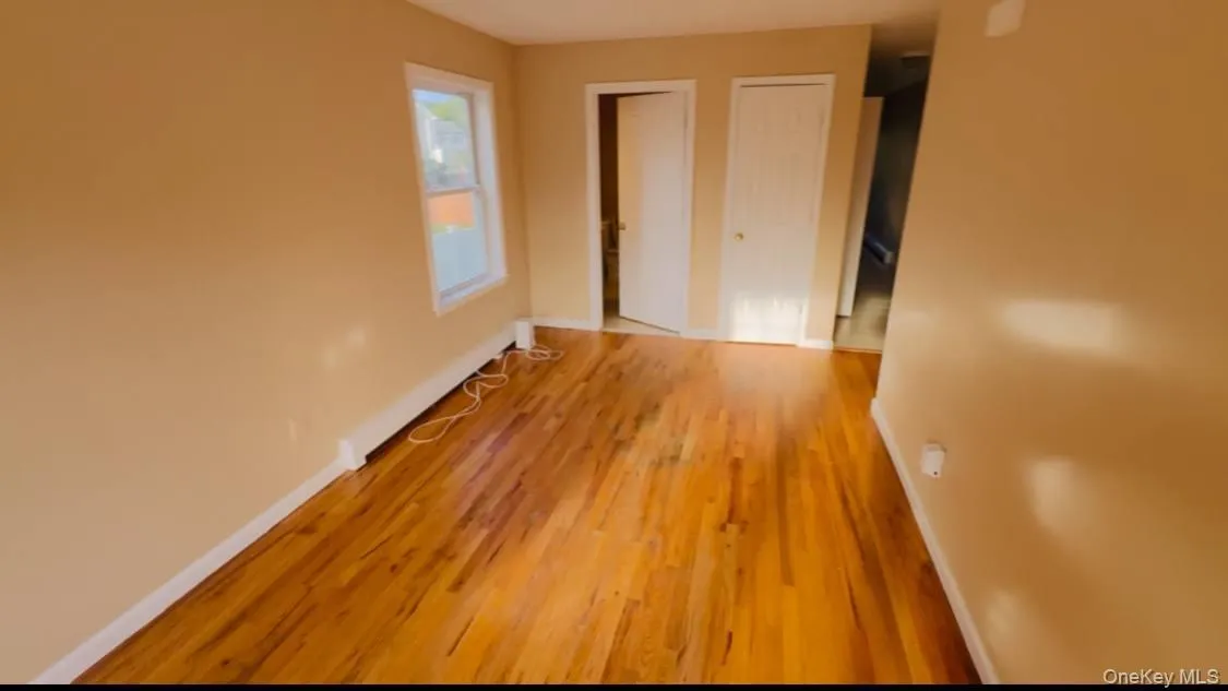 Unfurnished bedroom with light wood-style floors and multiple closets Unfurnished bedroom with light wood-style floors and multiple closets