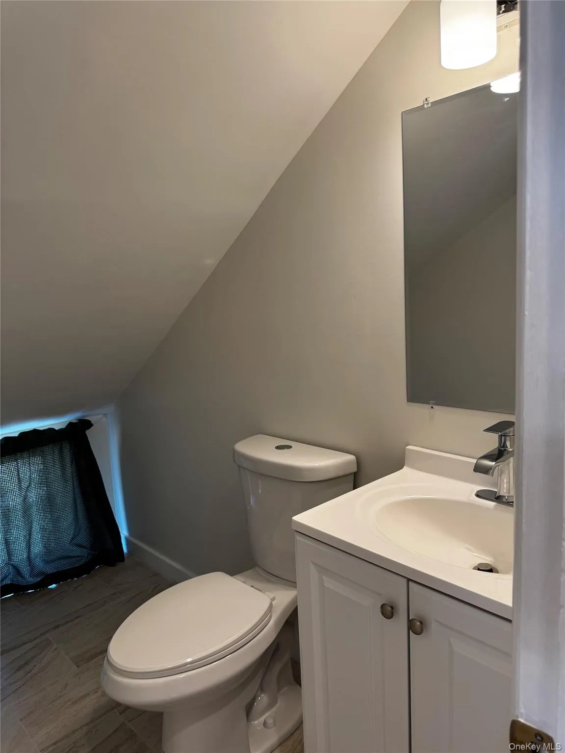 Half bathroom featuring vanity and vaulted ceiling Half bathroom featuring vanity and vaulted ceiling