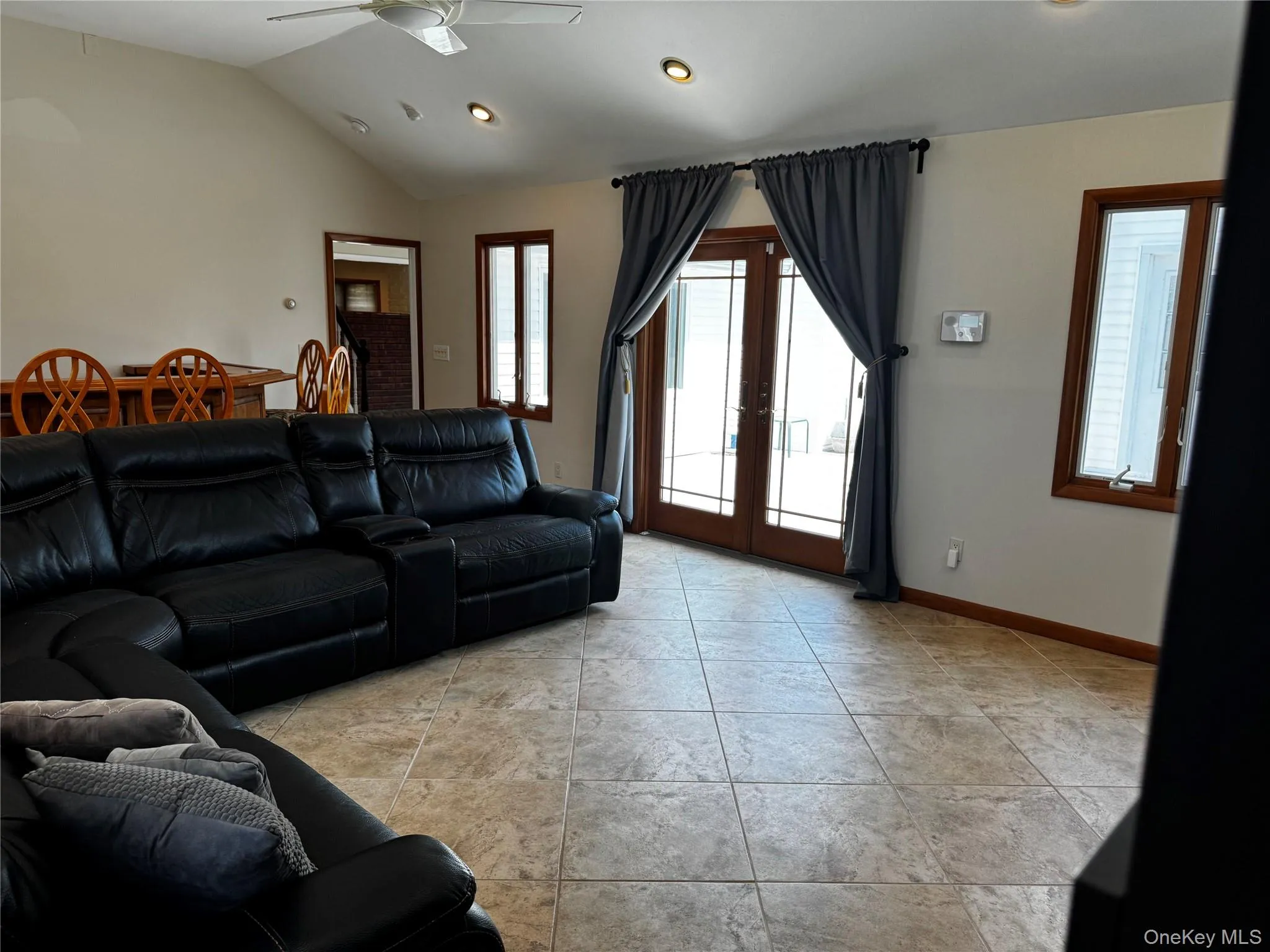 Living area with vaulted ceiling, french doors, recessed lighting, ceiling fan, and light tile patterned flooring Living area with vaulted ceiling, french doors, recessed lighting, ceiling fan, and light tile patterned flooring