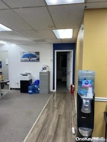 Office area featuring a paneled ceiling and wood finished floors Office area featuring a paneled ceiling and wood finished floors