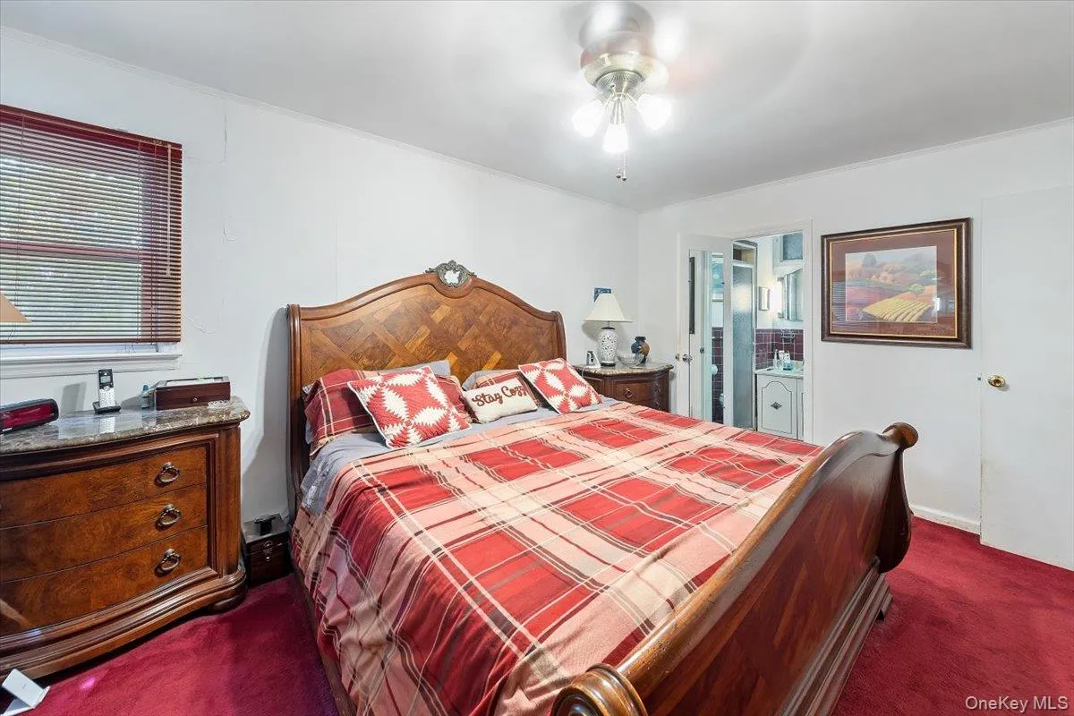 Bedroom featuring dark colored carpet, ceiling fan, and ensuite bathroom Bedroom featuring dark colored carpet, ceiling fan, and ensuite bathroom