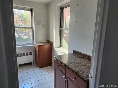Kitchen featuring tile patterned floors and radiator heating unit Kitchen featuring tile patterned floors and radiator heating unit