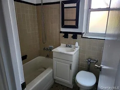 Full bathroom with tile walls, shower / tub combination, and vanity Full bathroom with tile walls, shower / tub combination, and vanity