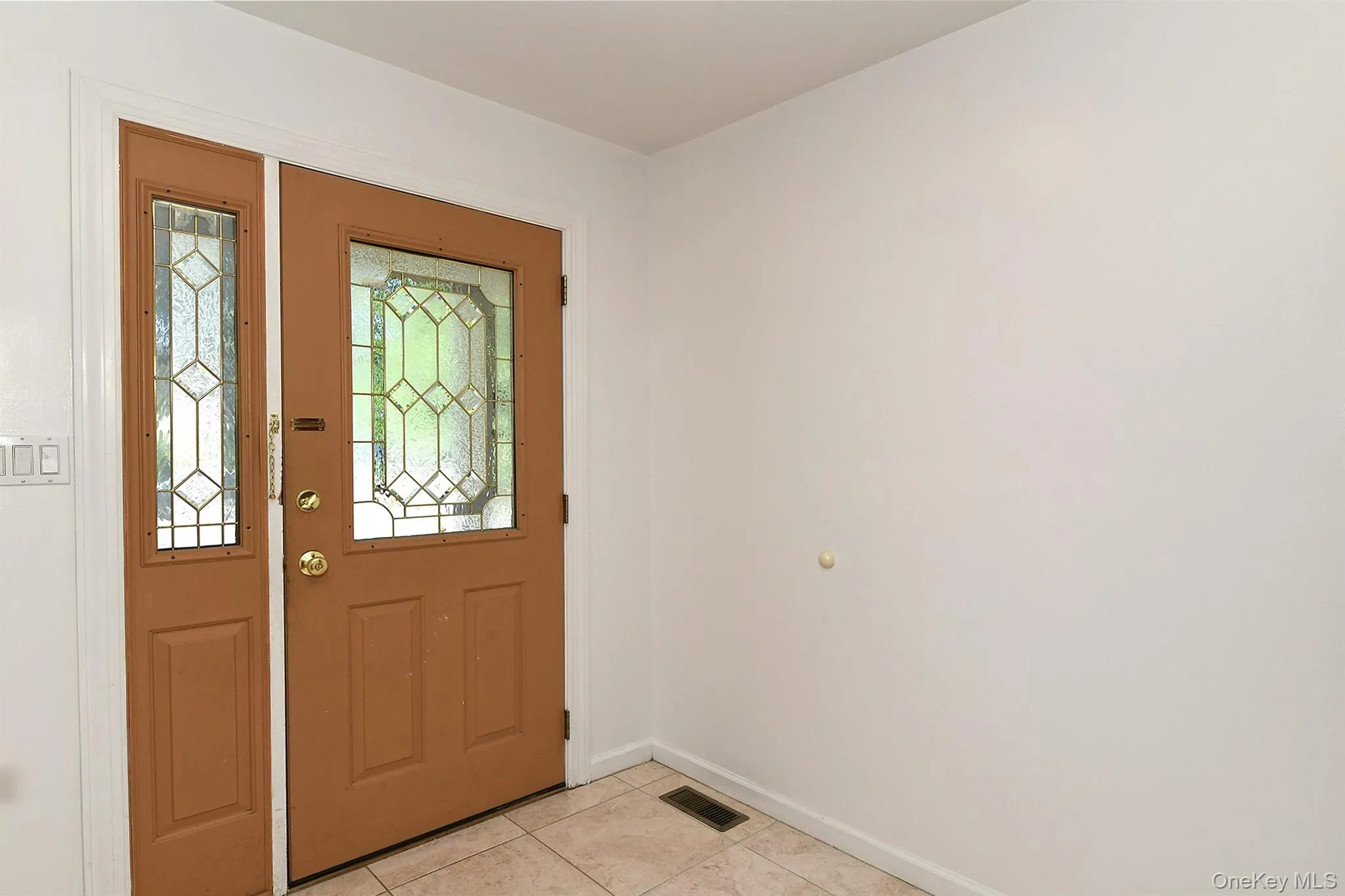 Entryway with light tile patterned floors and baseboards Entryway with light tile patterned floors and baseboards