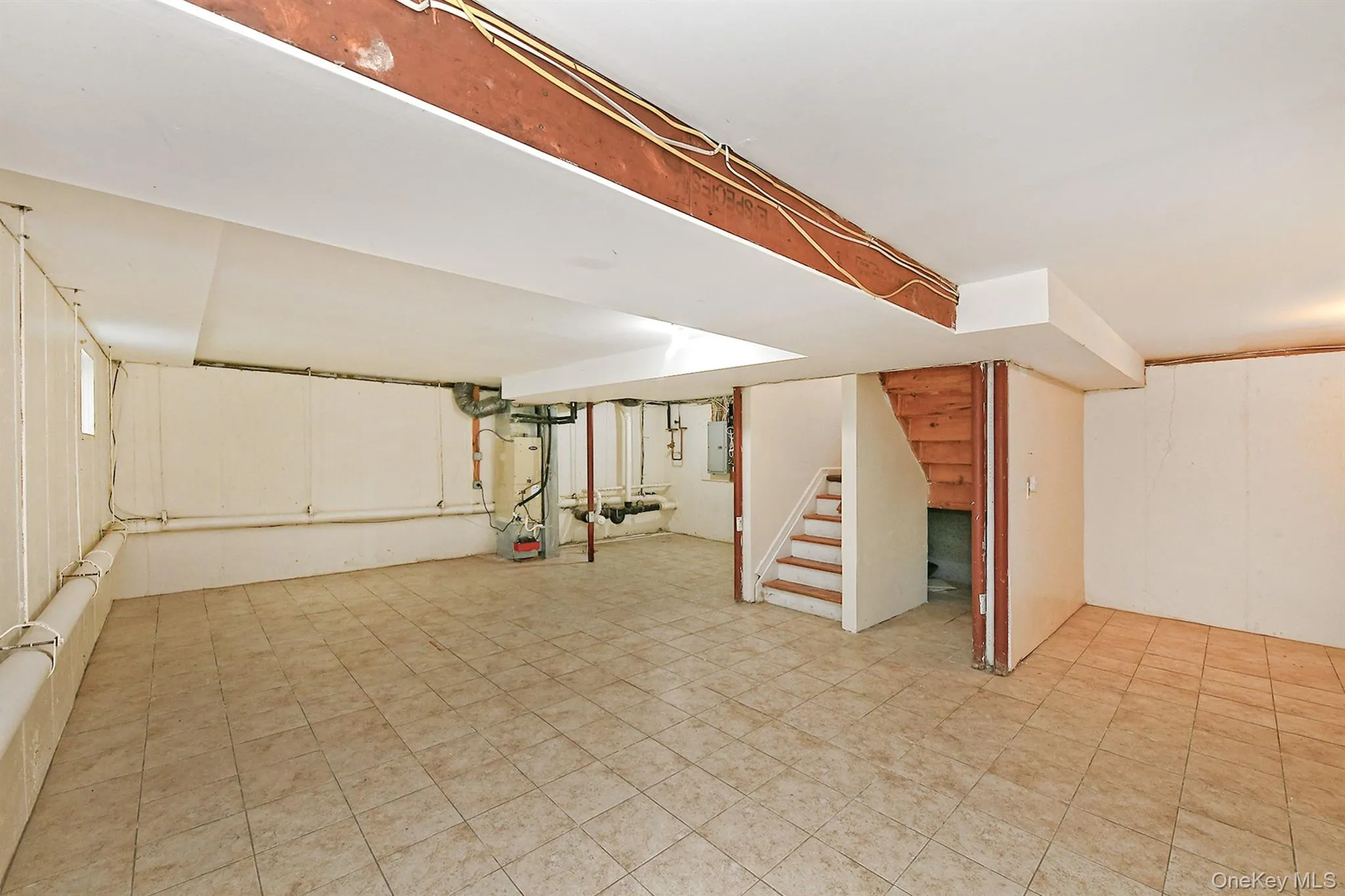 Below grade area with stairway, light flooring, and electric panel Below grade area with stairway, light flooring, and electric panel