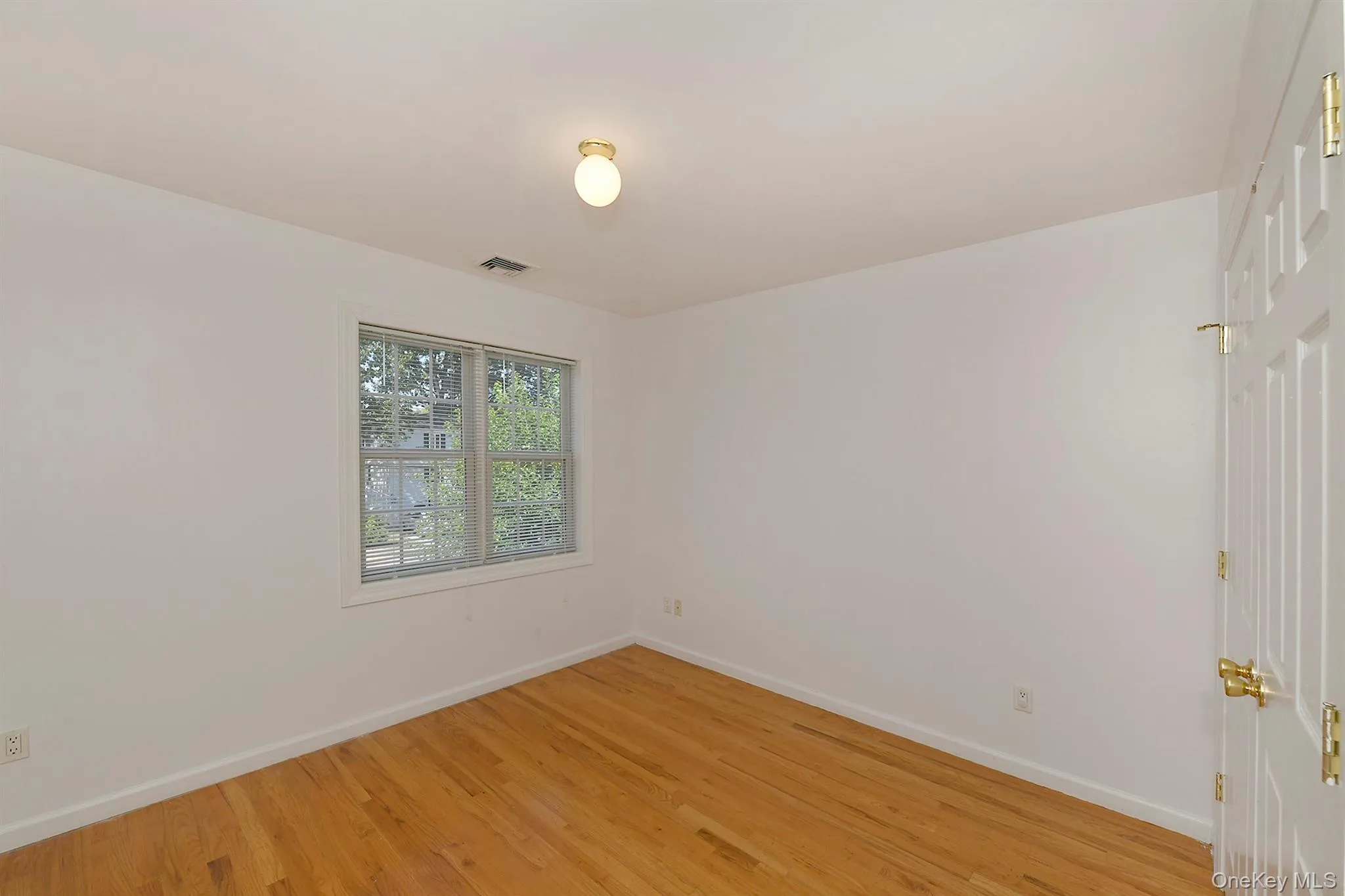 Spare room with baseboards and light wood-style floors Spare room with baseboards and light wood-style floors