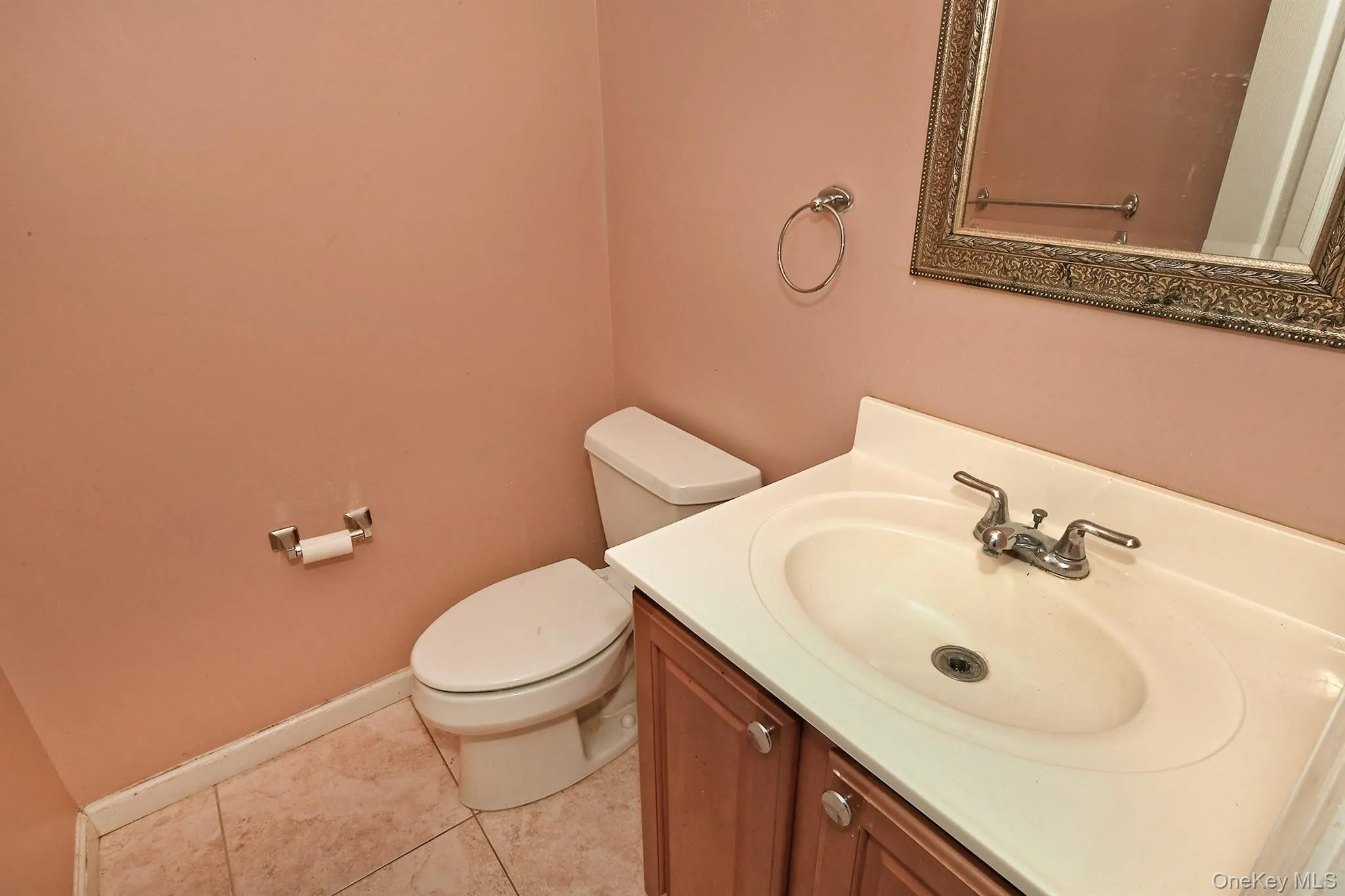 Half bathroom featuring vanity and light tile patterned floors Half bathroom featuring vanity and light tile patterned floors