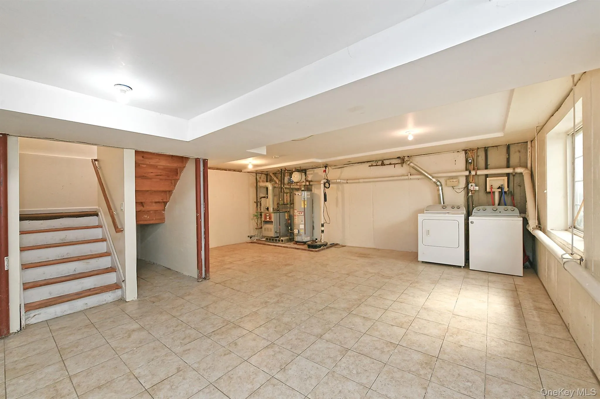Basement featuring stairway, separate washer and dryer, a heating unit, and gas water heater Basement featuring stairway, separate washer and dryer, a heating unit, and gas water heater