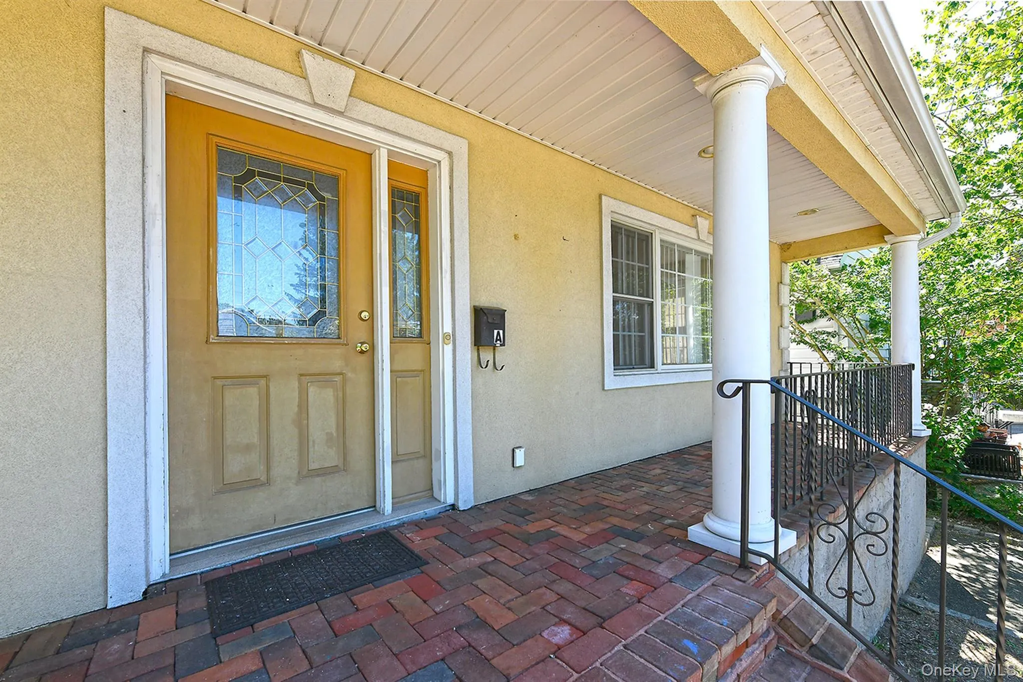 Property entrance featuring a porch and stucco siding Property entrance featuring a porch and stucco siding
