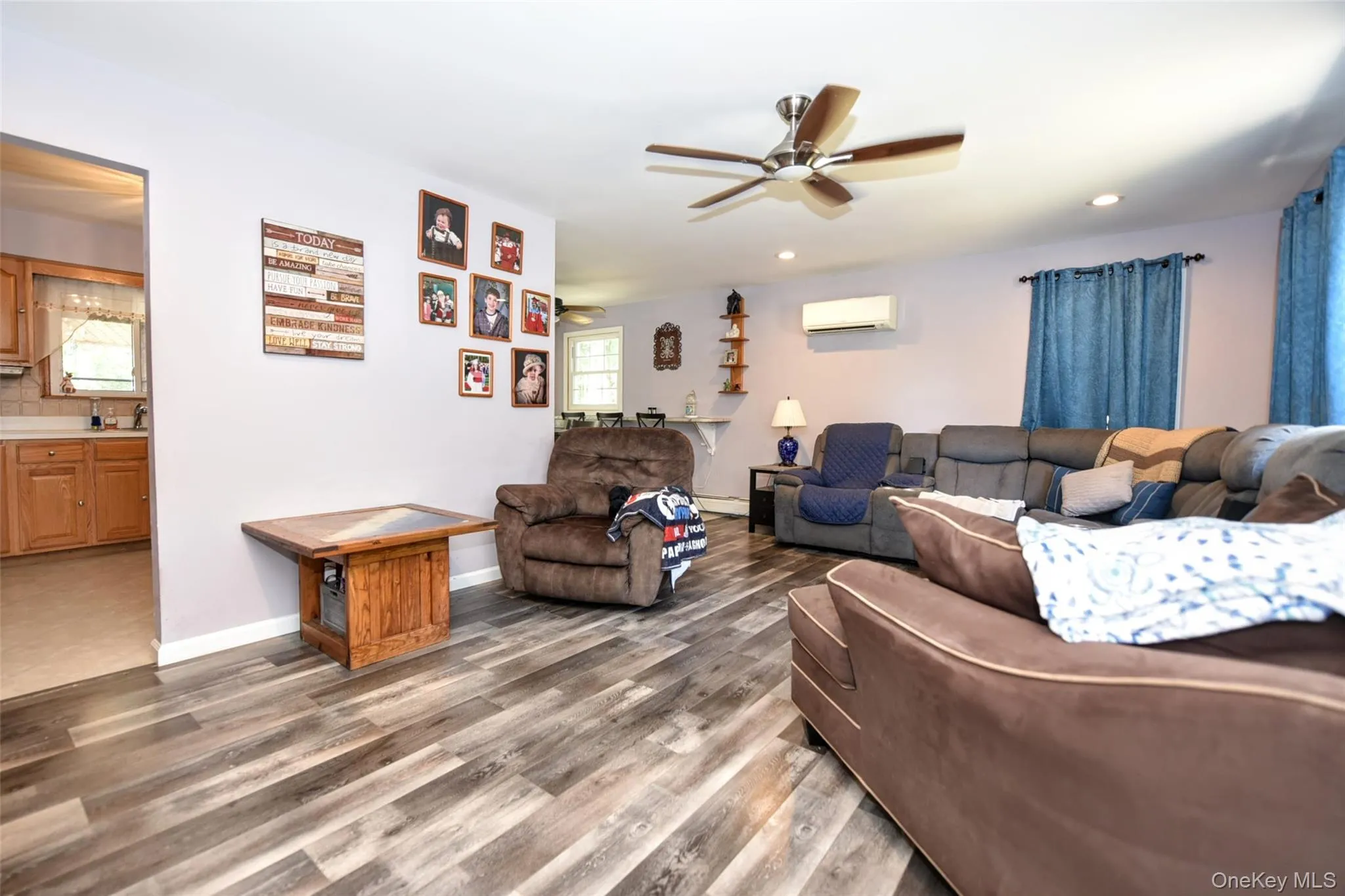 Living room with a ceiling fan, dark wood-type flooring, recessed lighting, and an AC wall unit Living room with a ceiling fan, dark wood-type flooring, recessed lighting, and an AC wall unit