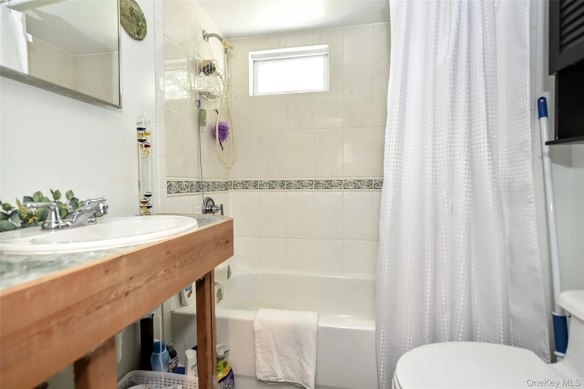 Full bath featuring shower / tub combo with curtain and toilet Full bath featuring shower / tub combo with curtain and toilet