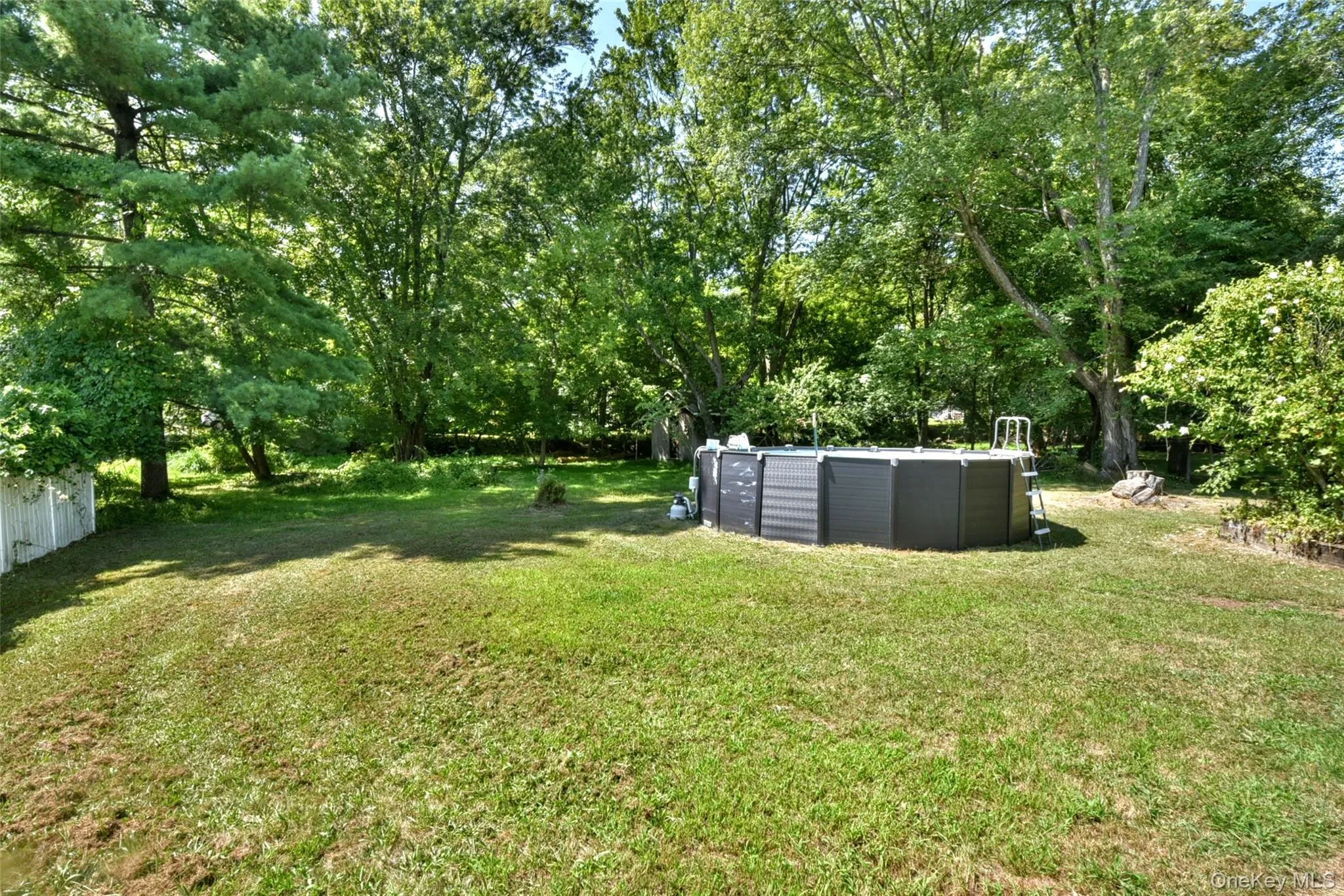View of yard with view of wooded area and an outdoor pool View of yard with view of wooded area and an outdoor pool