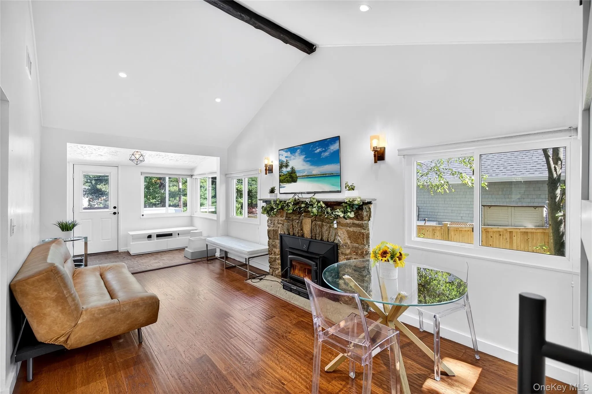 Living room featuring beam ceiling, high vaulted ceiling, wood finished floors, recessed lighting, and plenty of natural light Living room featuring beam ceiling, high vaulted ceiling, wood finished floors, recessed lighting, and plenty of natural light