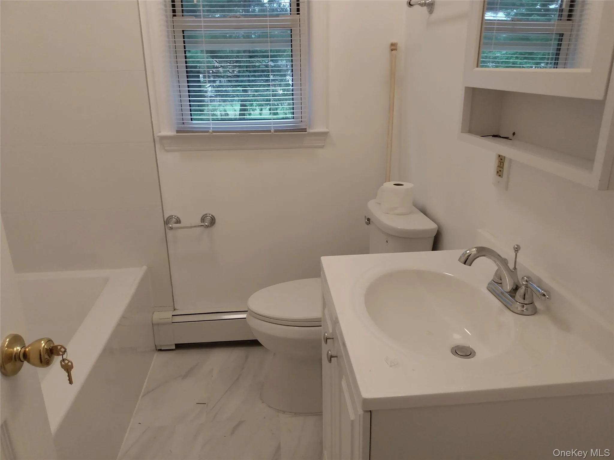 Full bathroom featuring vanity and a baseboard radiator Full bathroom featuring vanity and a baseboard radiator