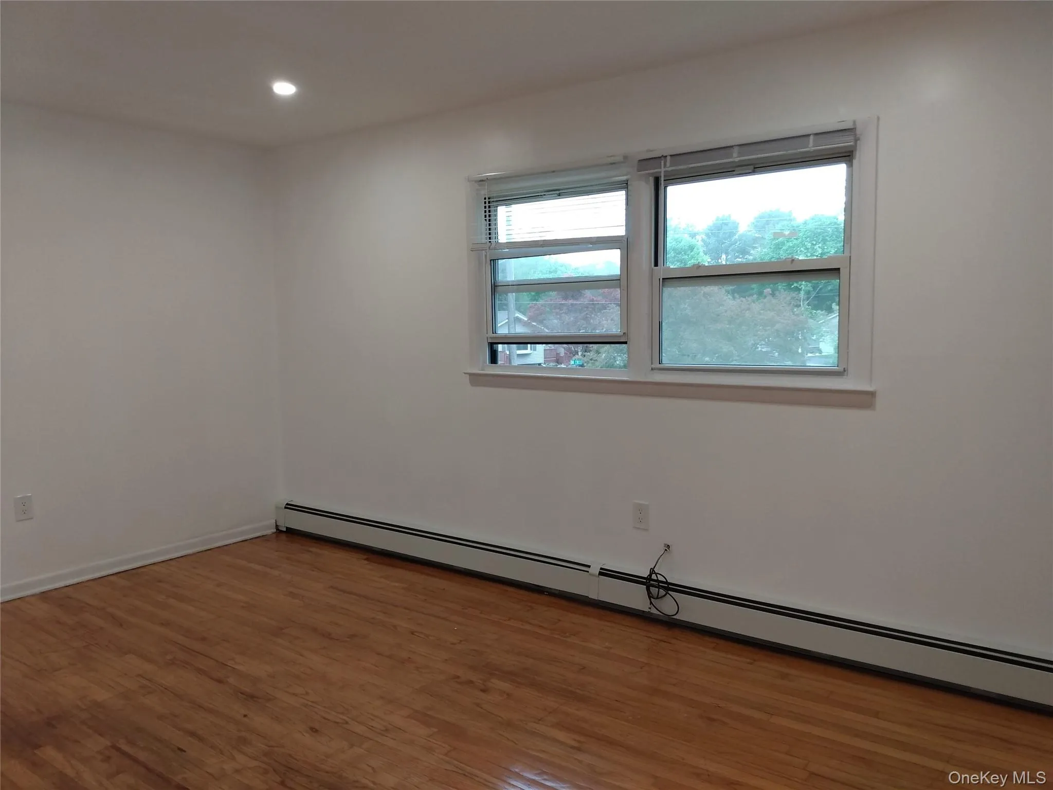 Spare room with baseboard heating, hardwood flooring, and recessed lighting Spare room with baseboard heating, hardwood flooring, and recessed lighting
