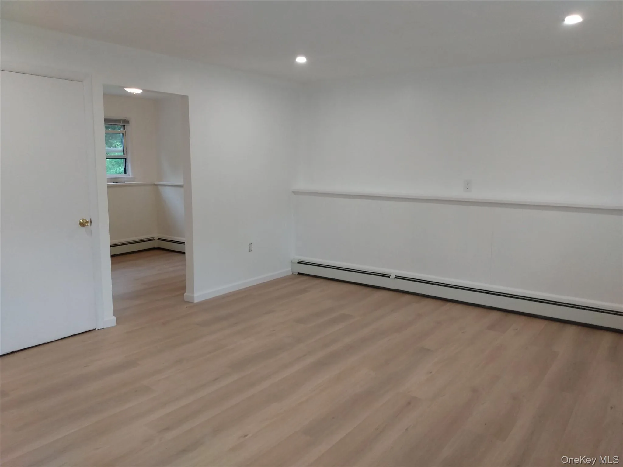 Spare room with light finished floors, a baseboard radiator, and recessed lighting Spare room with light finished floors, a baseboard radiator, and recessed lighting