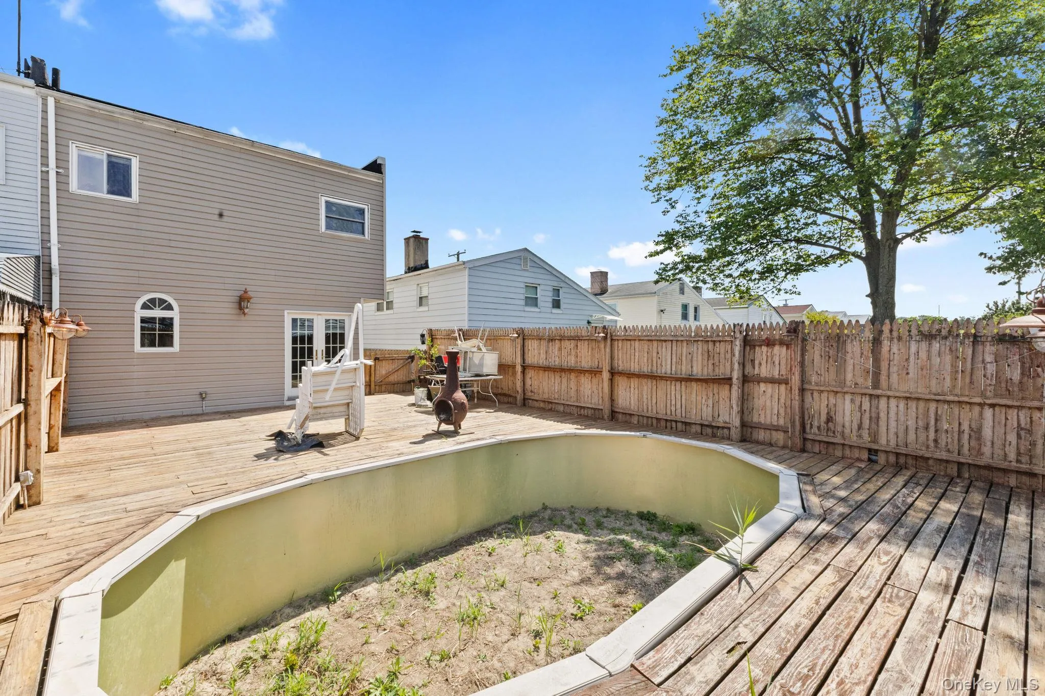 Rear view of house with a wooden deck and a fenced backyard Rear view of house with a wooden deck and a fenced backyard