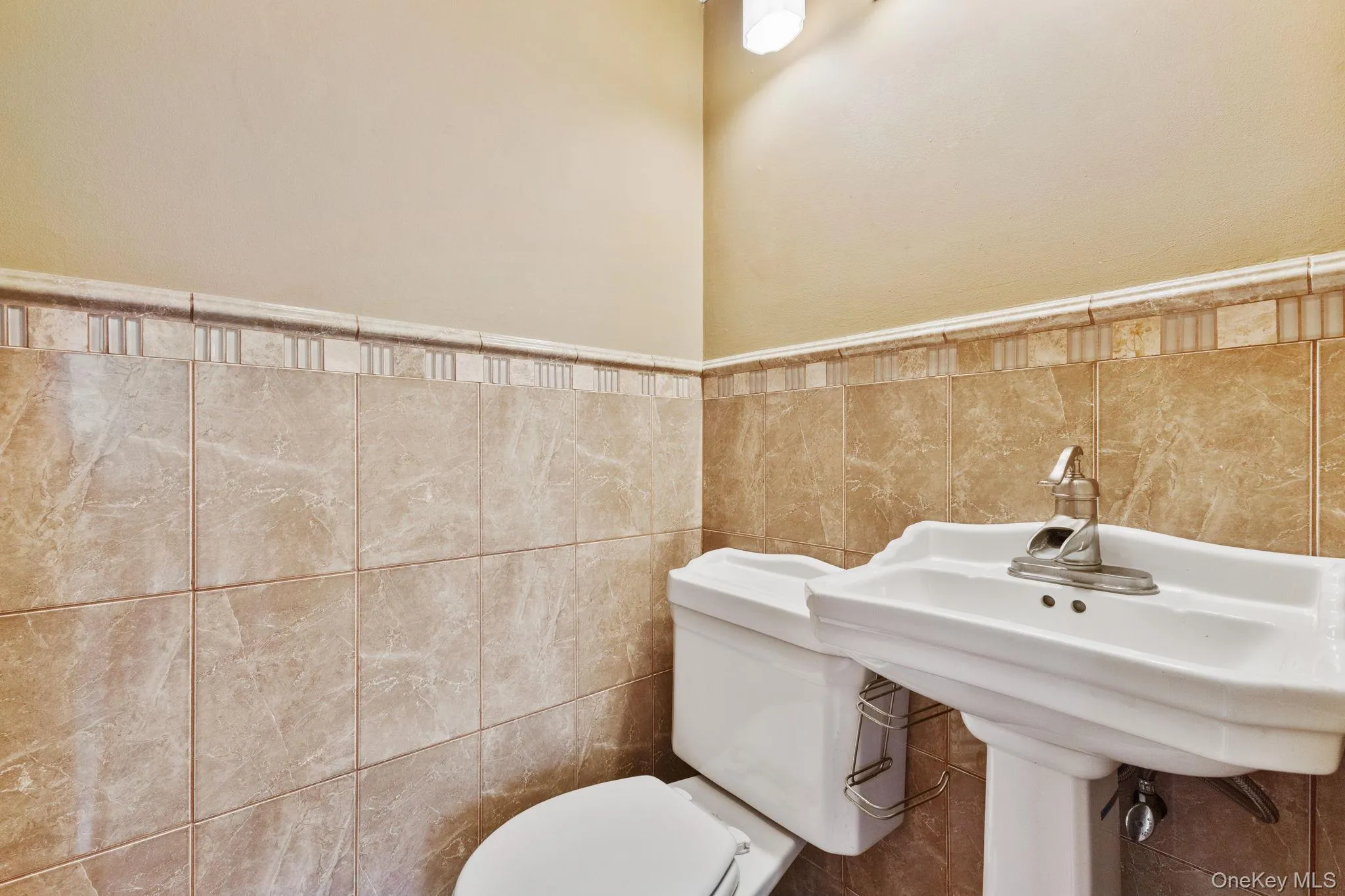 Half bath with tile walls and wainscoting Half bath with tile walls and wainscoting