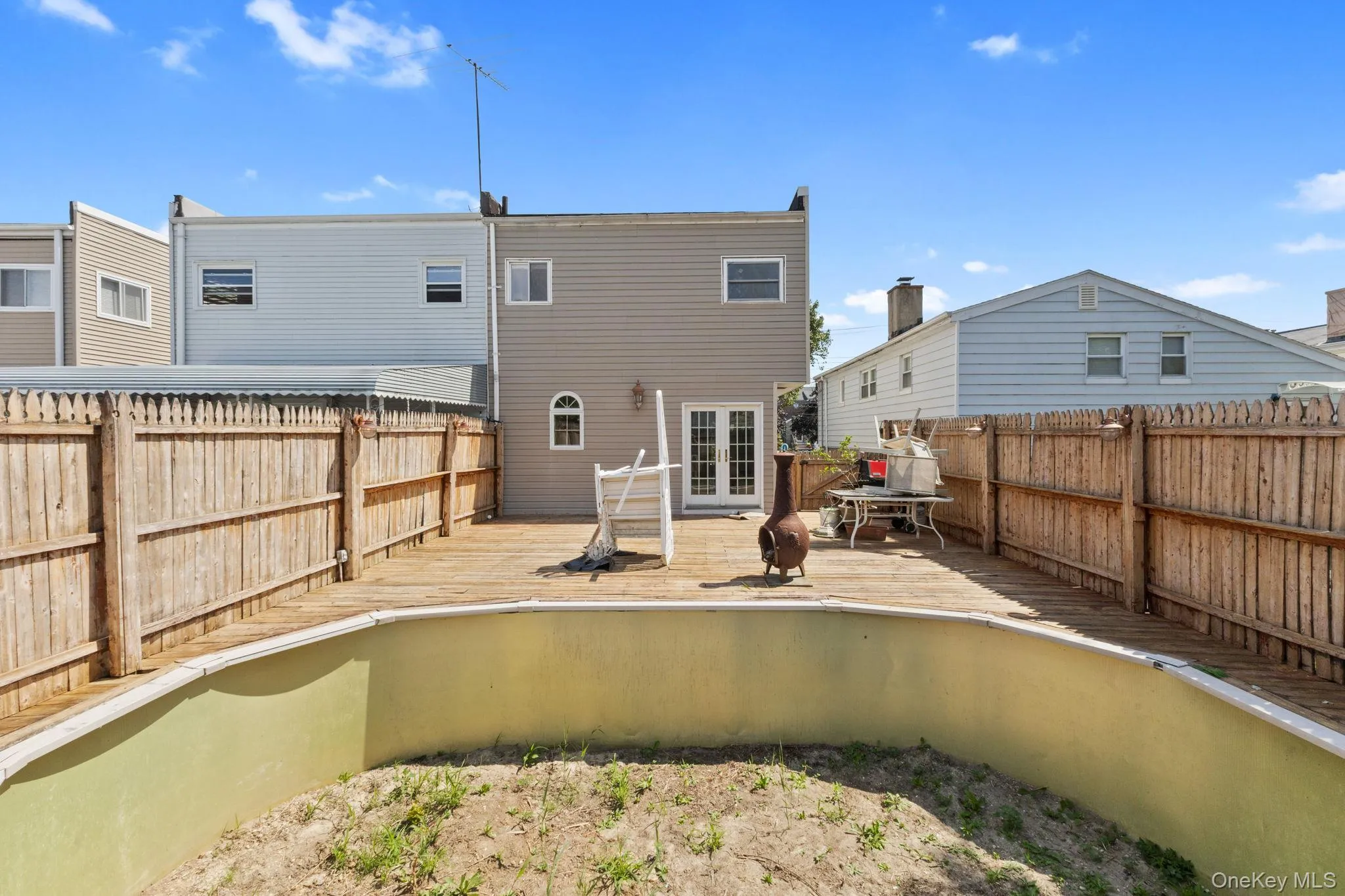 Back of property featuring a fenced backyard, a deck, and french doors Back of property featuring a fenced backyard, a deck, and french doors
