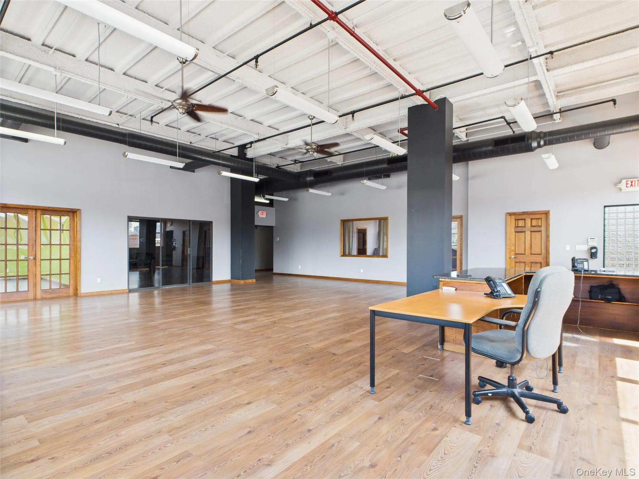 Home office with light wood-type flooring, a towering ceiling, and ceiling fan Home office with light wood-type flooring, a towering ceiling, and ceiling fan