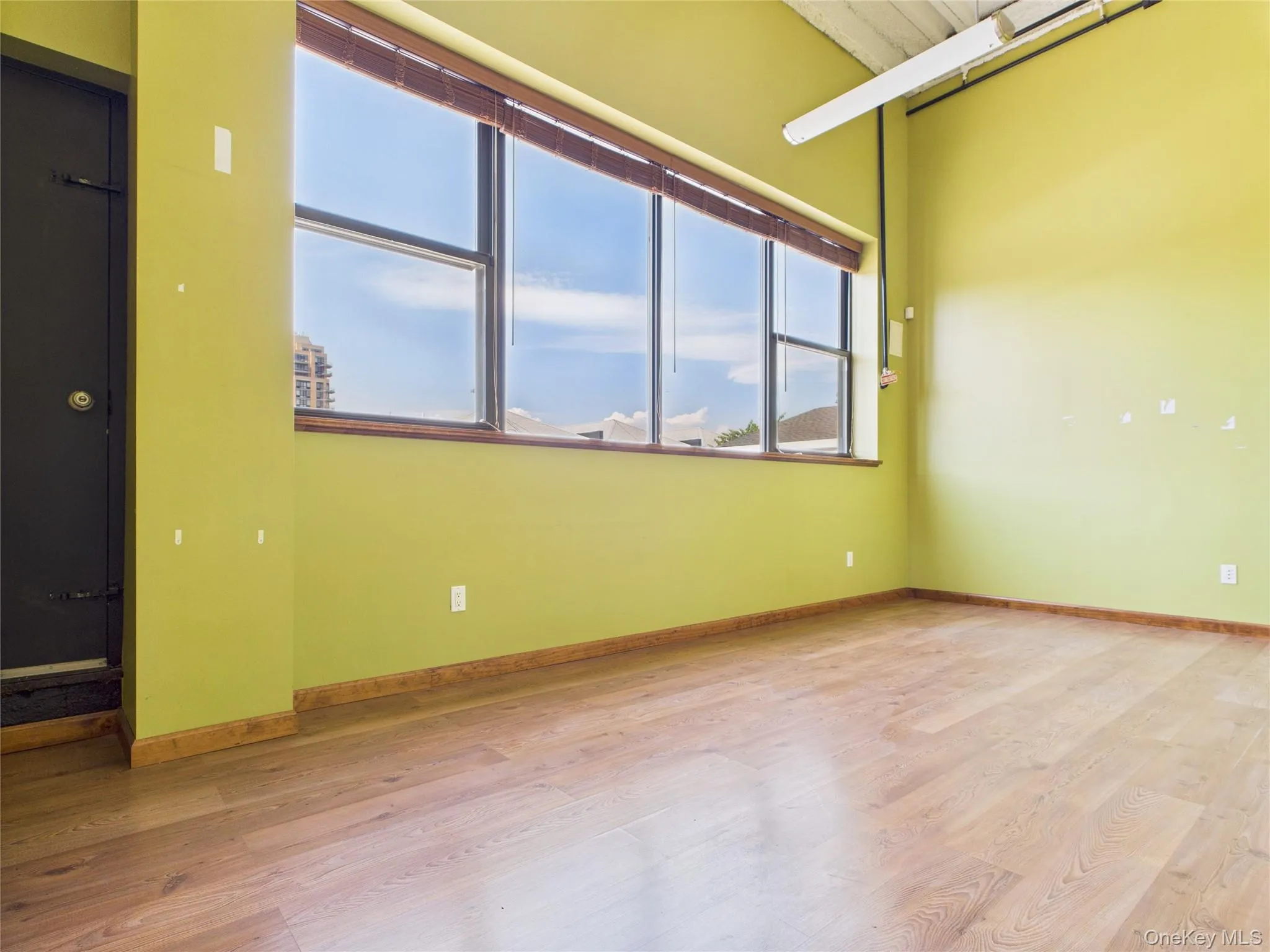 Empty room with light wood-style flooring and baseboards Empty room with light wood-style flooring and baseboards