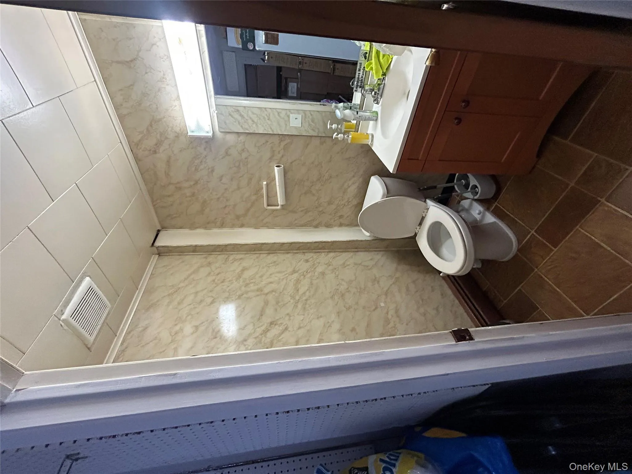 Bathroom with vanity, dark tile patterned flooring, and baseboard heating Bathroom with vanity, dark tile patterned flooring, and baseboard heating