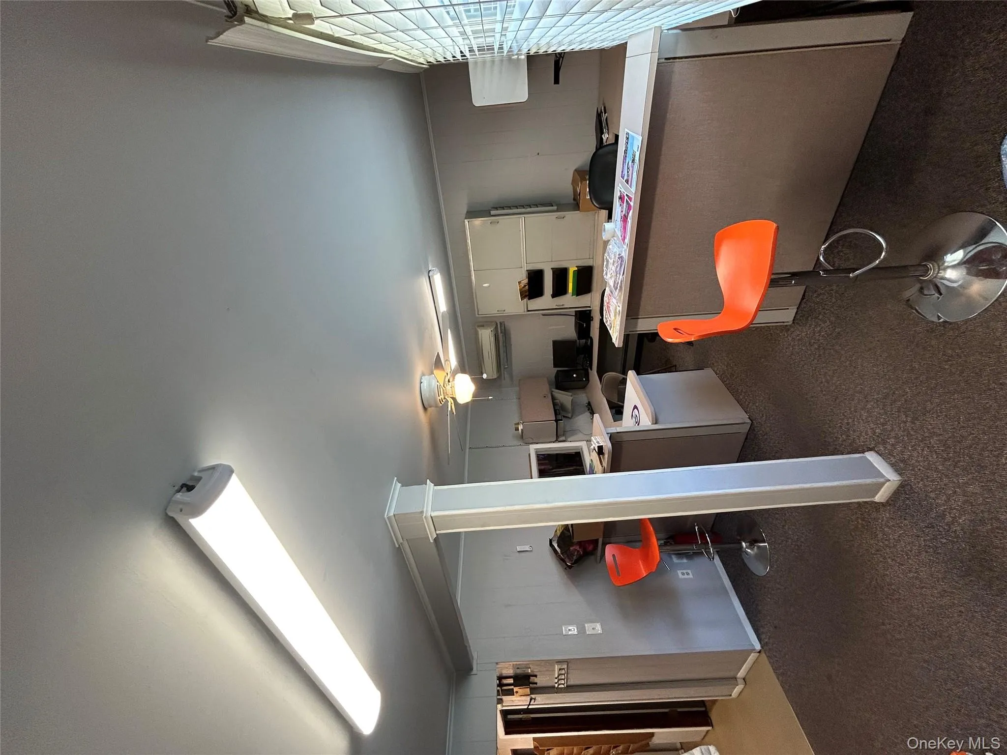 Kitchen with dark carpet, light countertops, a ceiling fan, a peninsula, and wooden walls Kitchen with dark carpet, light countertops, a ceiling fan, a peninsula, and wooden walls